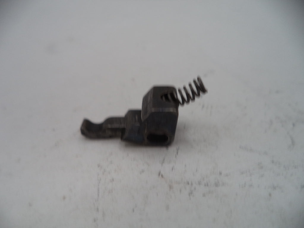 Small mechanical component with a spring on a light gray surface