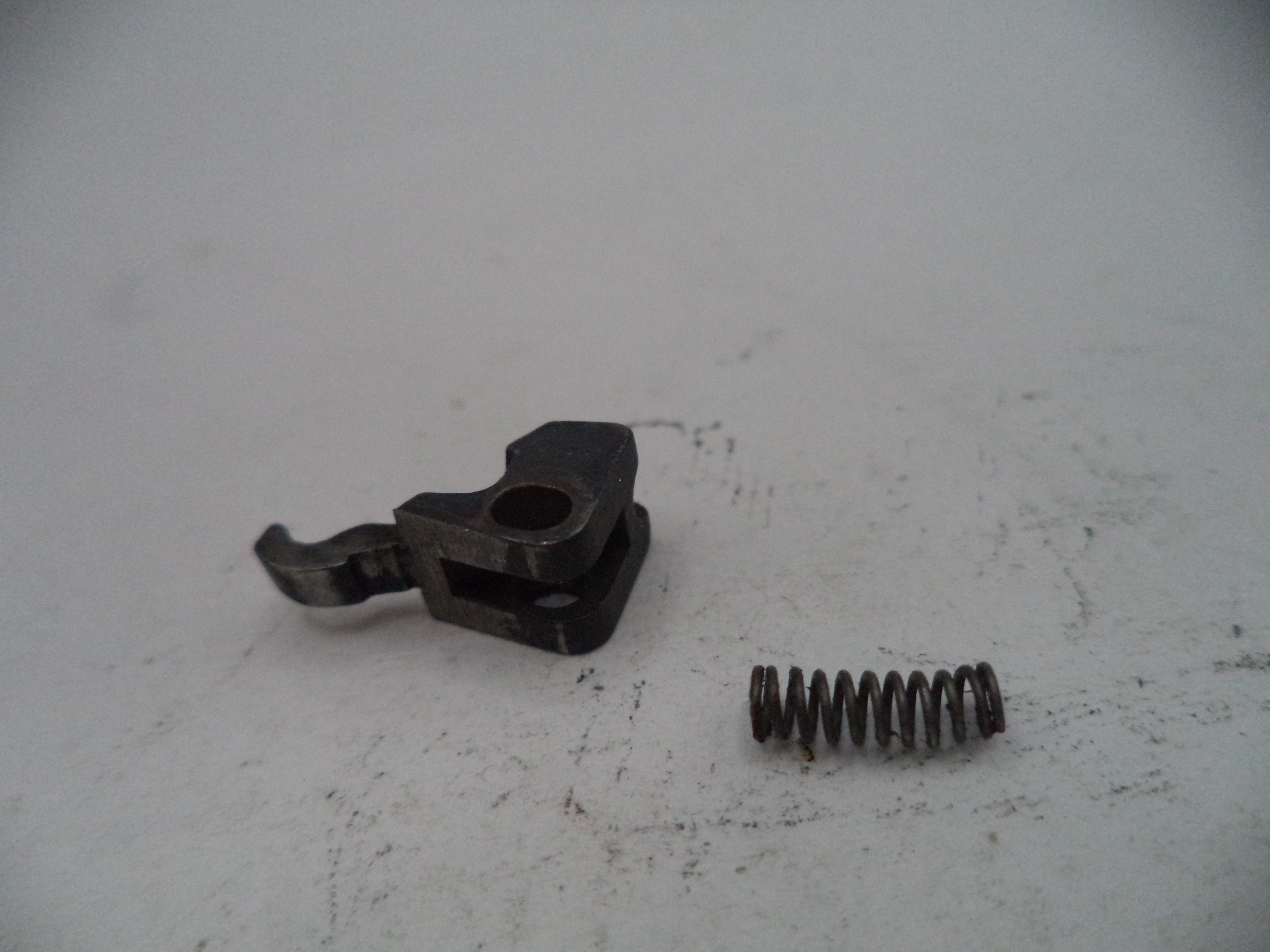 Mechanical component and spring on a white surface