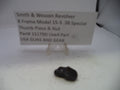 Small black object on a white surface with a sign about a Smith & Wesson revolver part.