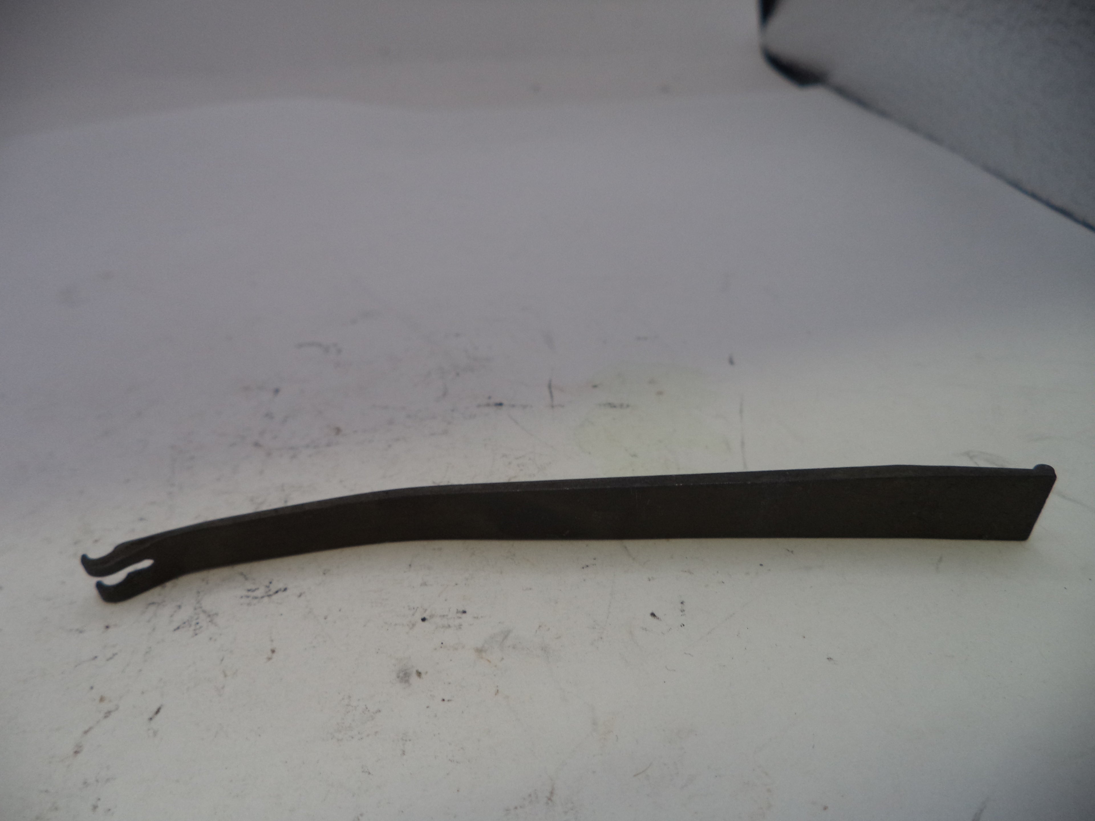 Black metal tool on a white surface