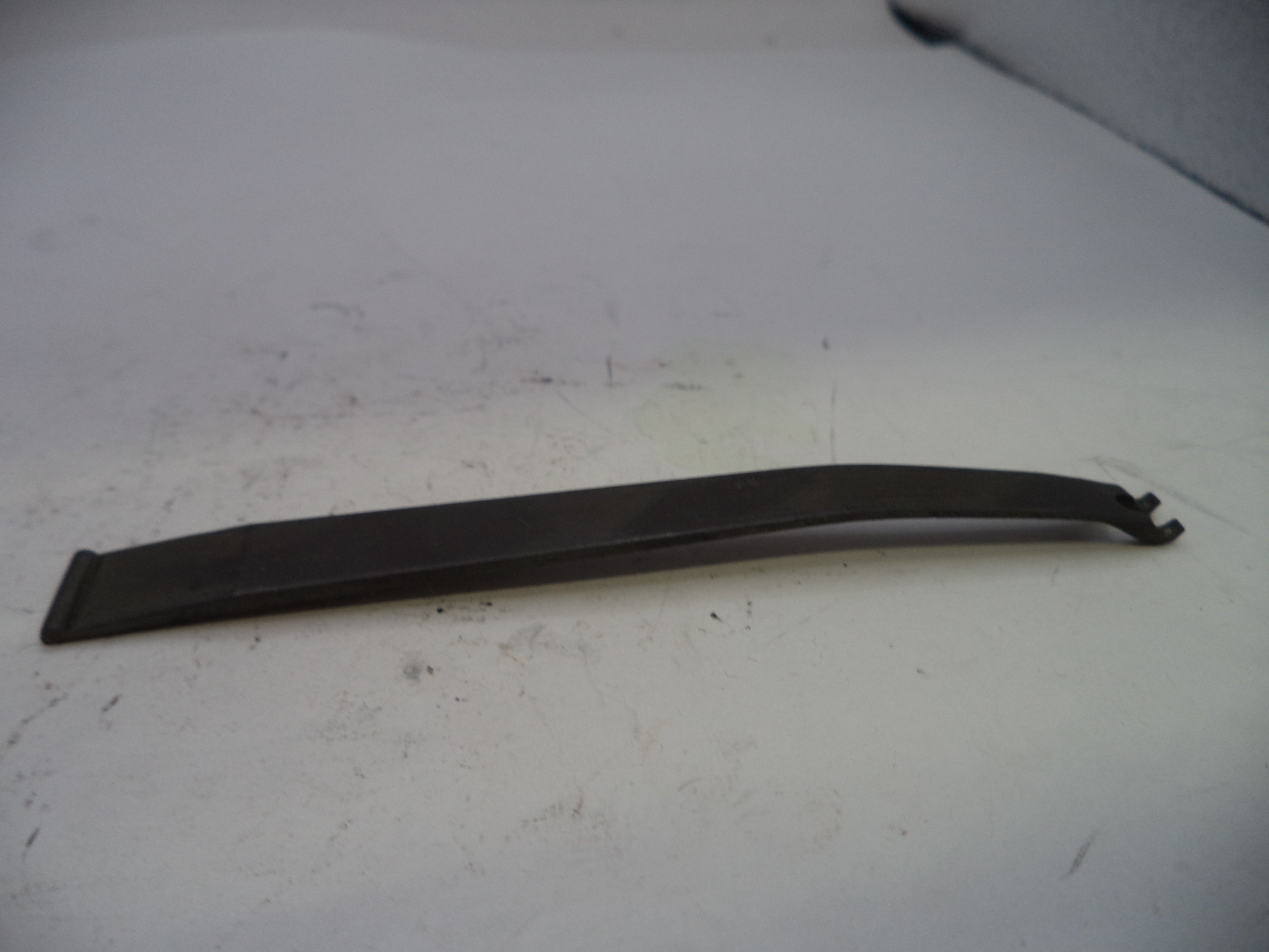 Black plastic trim piece on a white surface