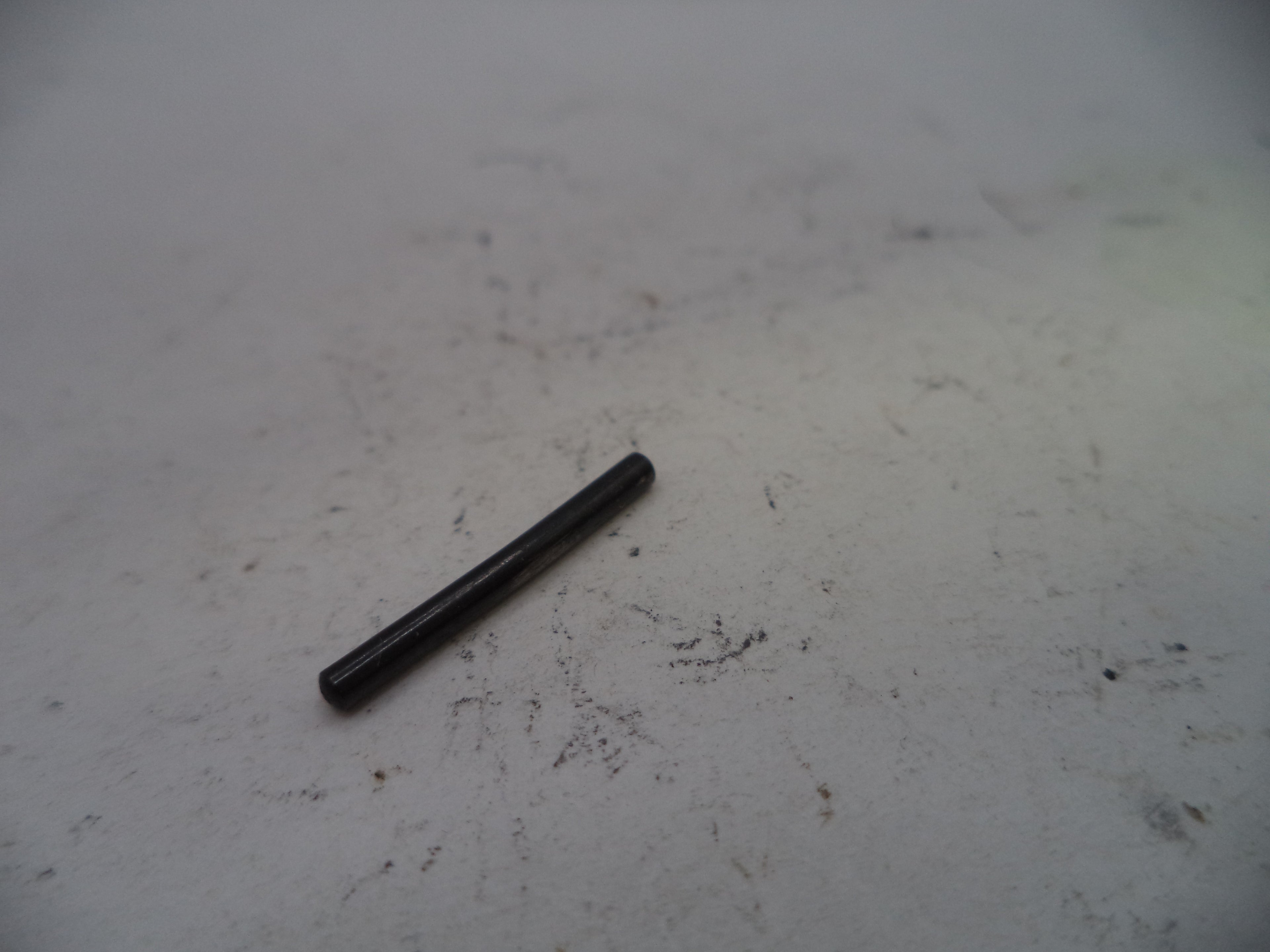 Black cylindrical object on a textured white surface