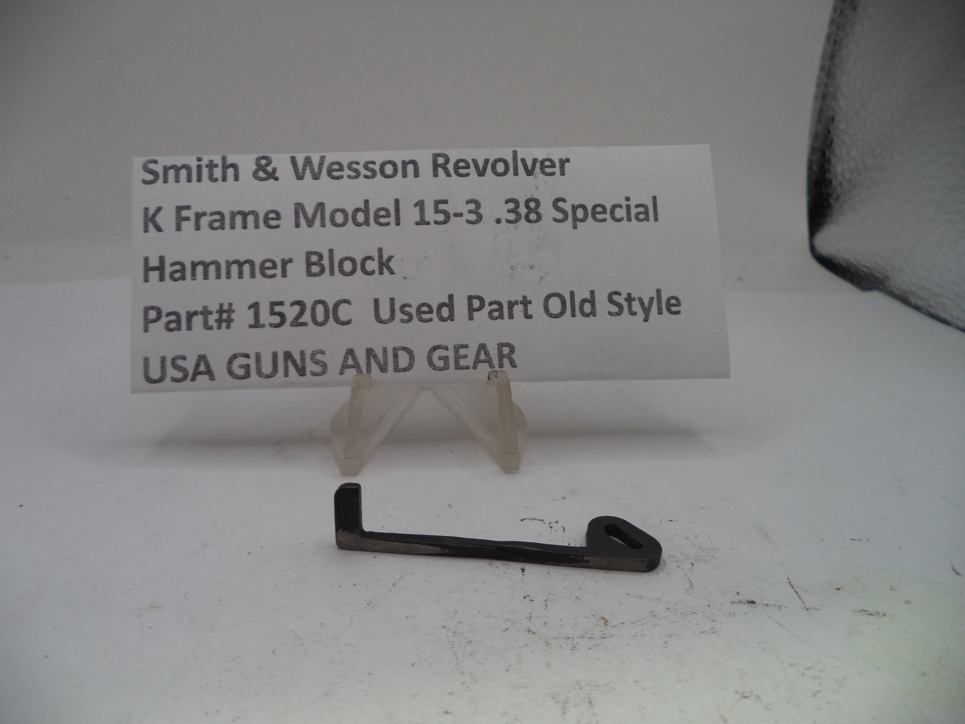 Smith & Wesson revolver hammer block part on a white background with a label.