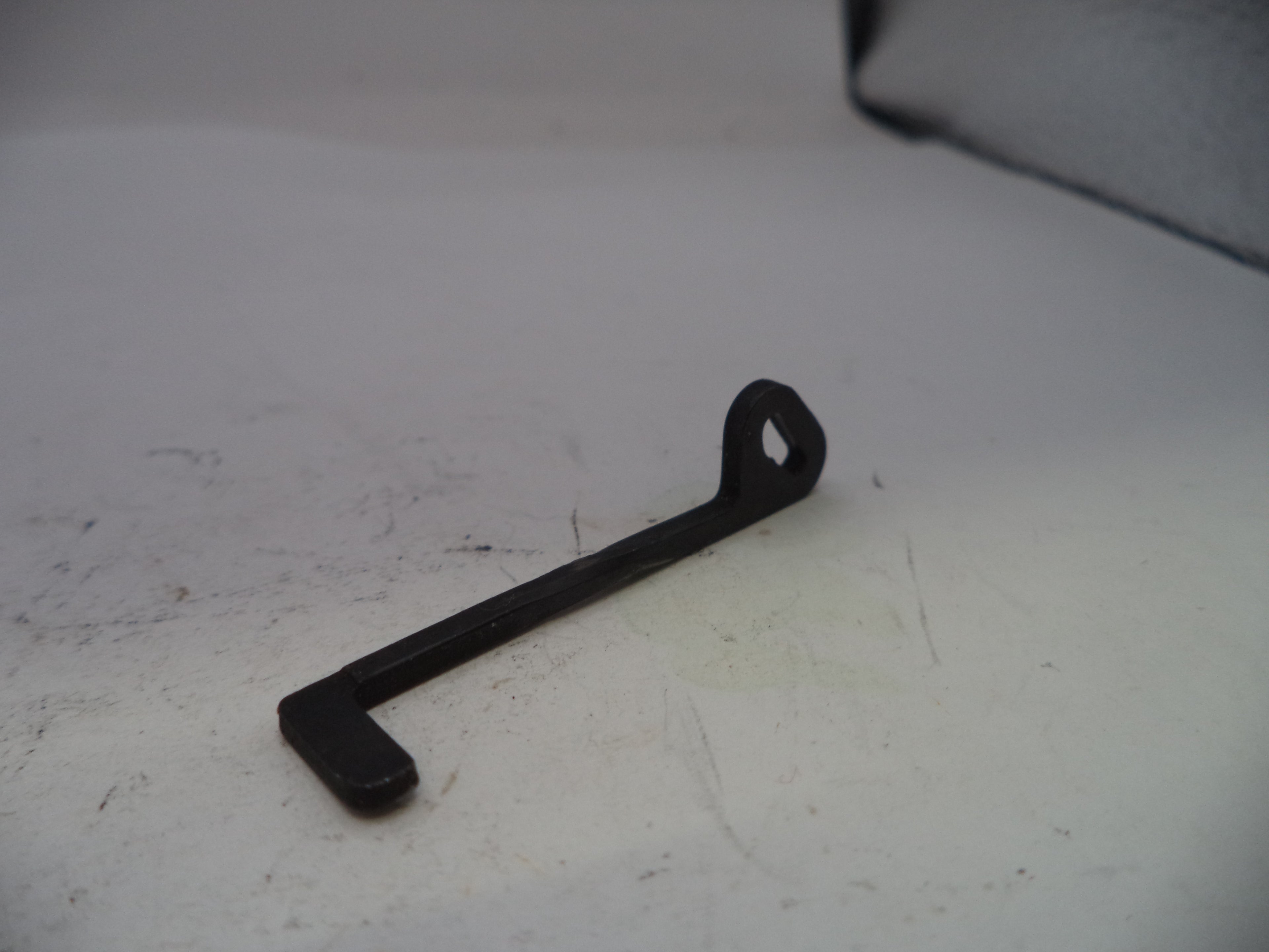 Black metal wrench on a white surface