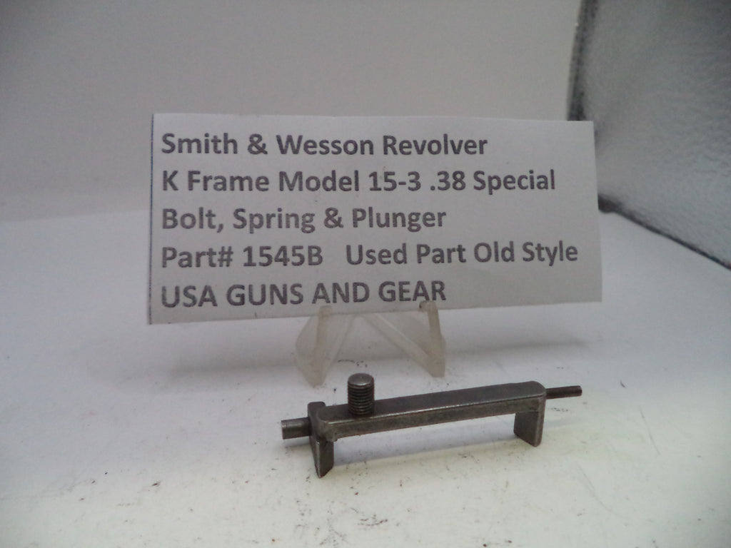 Small metal gun part with descriptive card on a white background