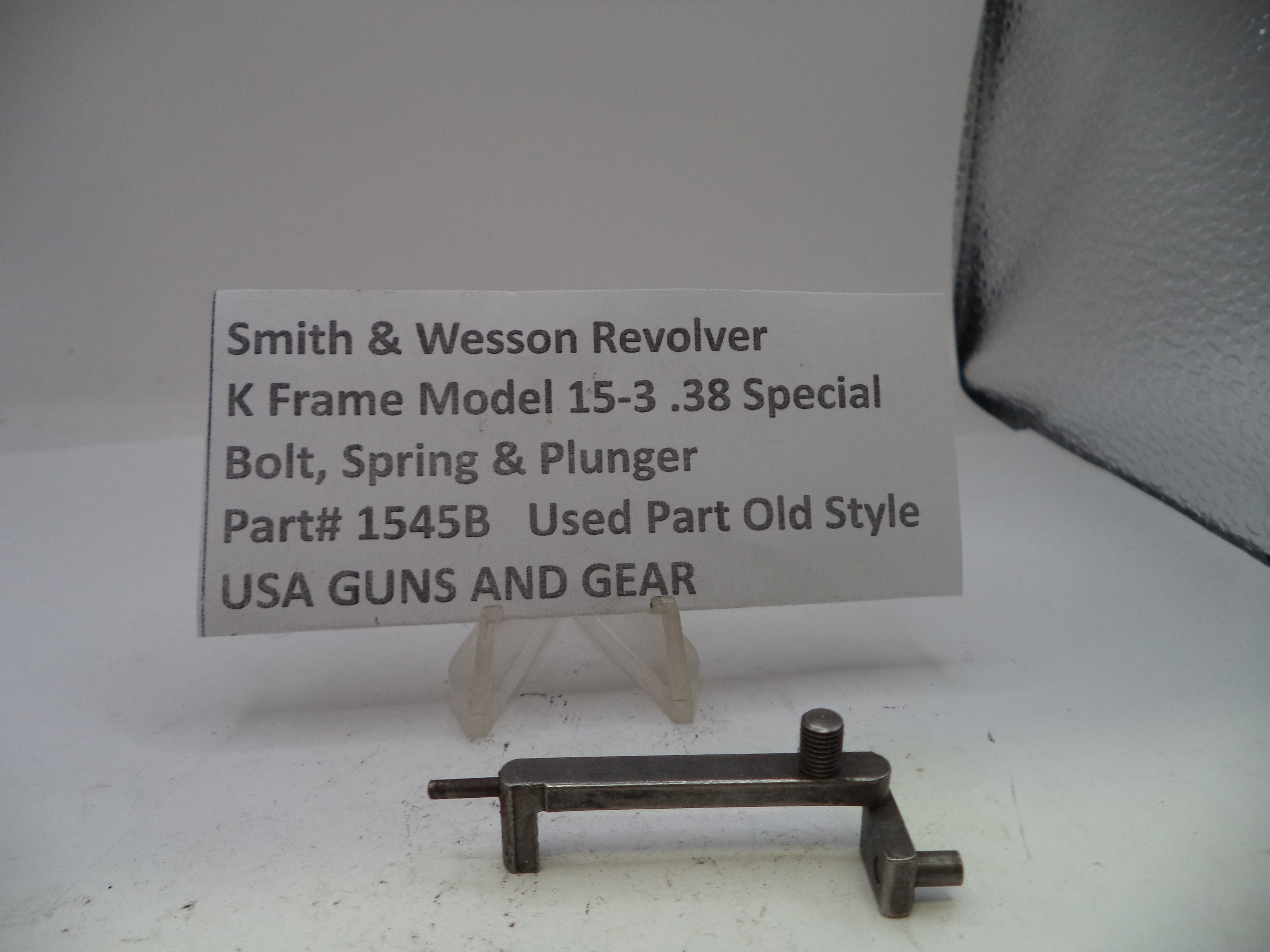 Smith & Wesson revolver part with descriptive card on a white background