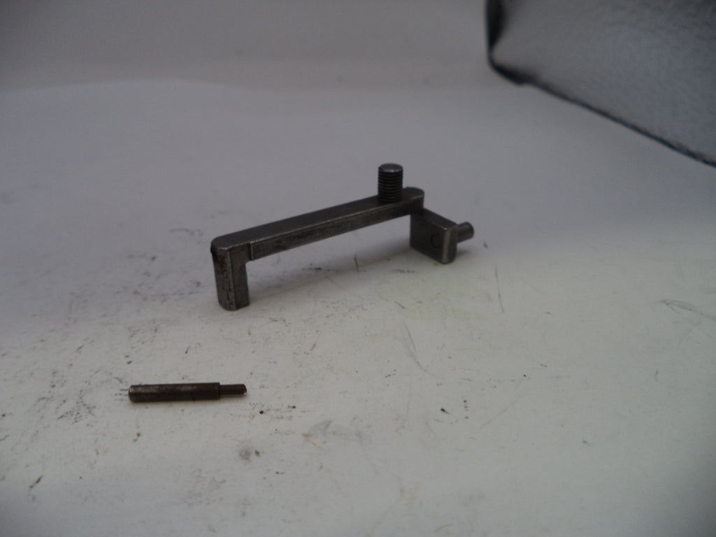 Metal lever and small cylindrical object on a white surface