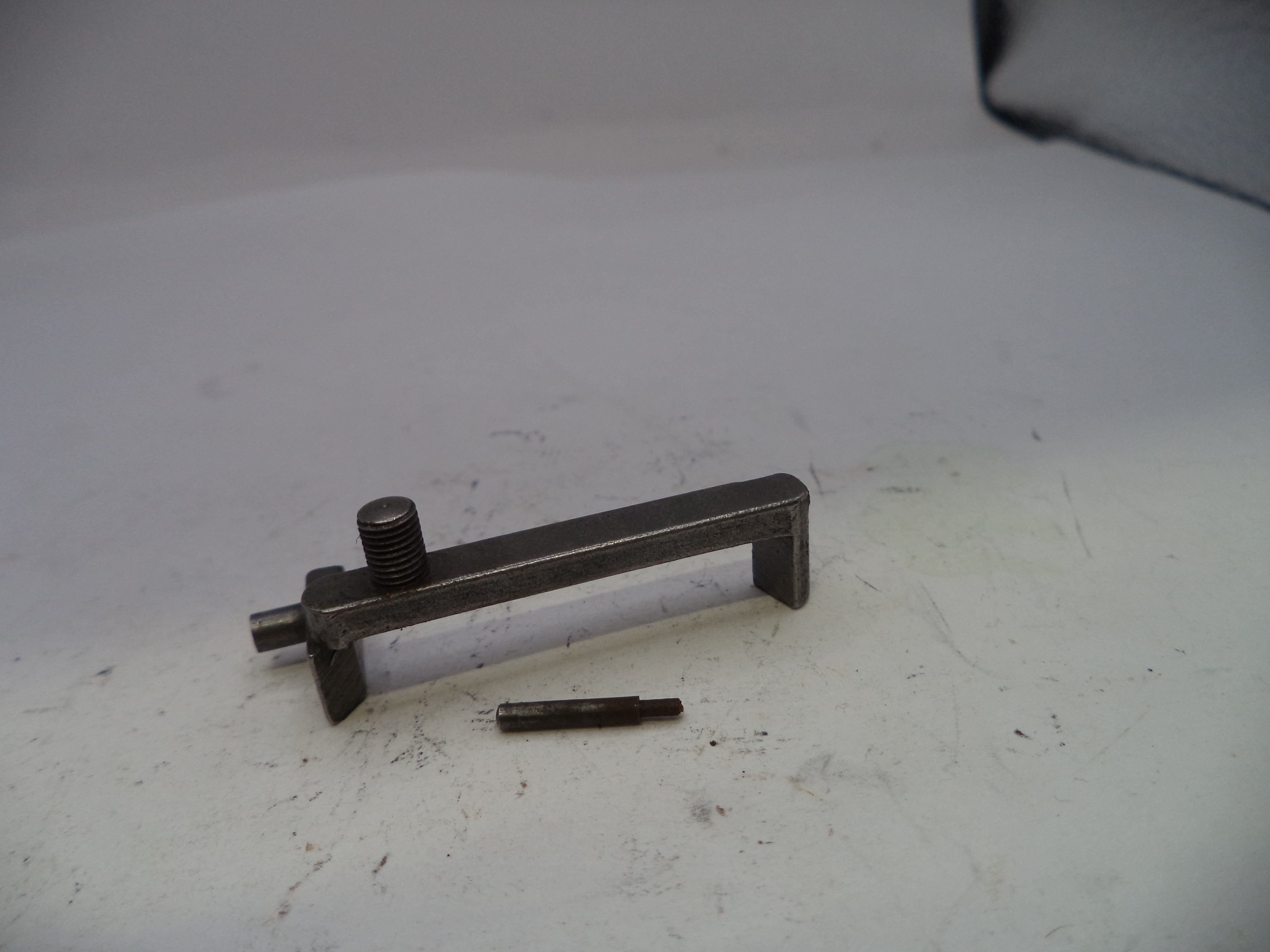 Metal lever and screw on a white surface