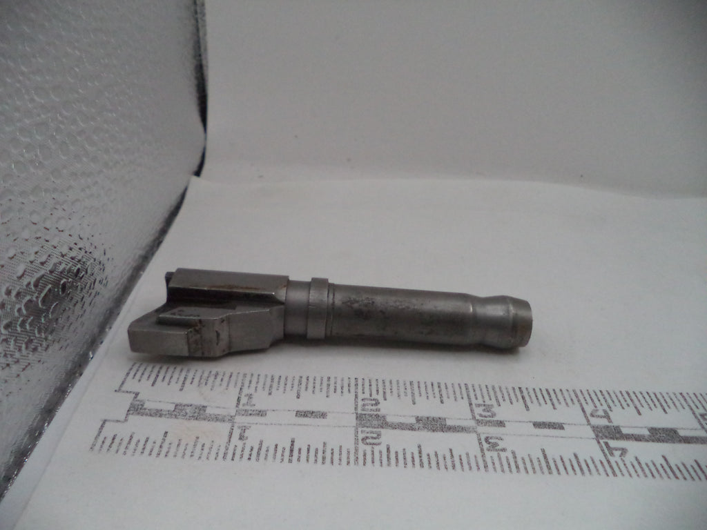 Metal component on a white surface with a ruler for scale