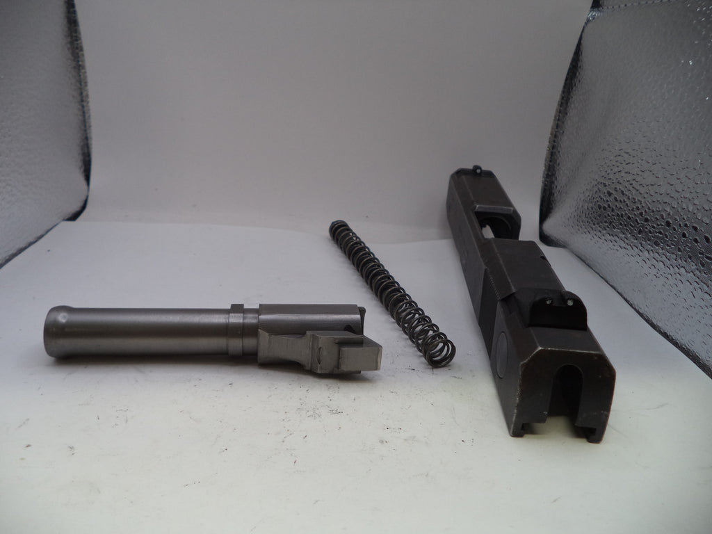 Three gun components on a white surface with a gray textured background