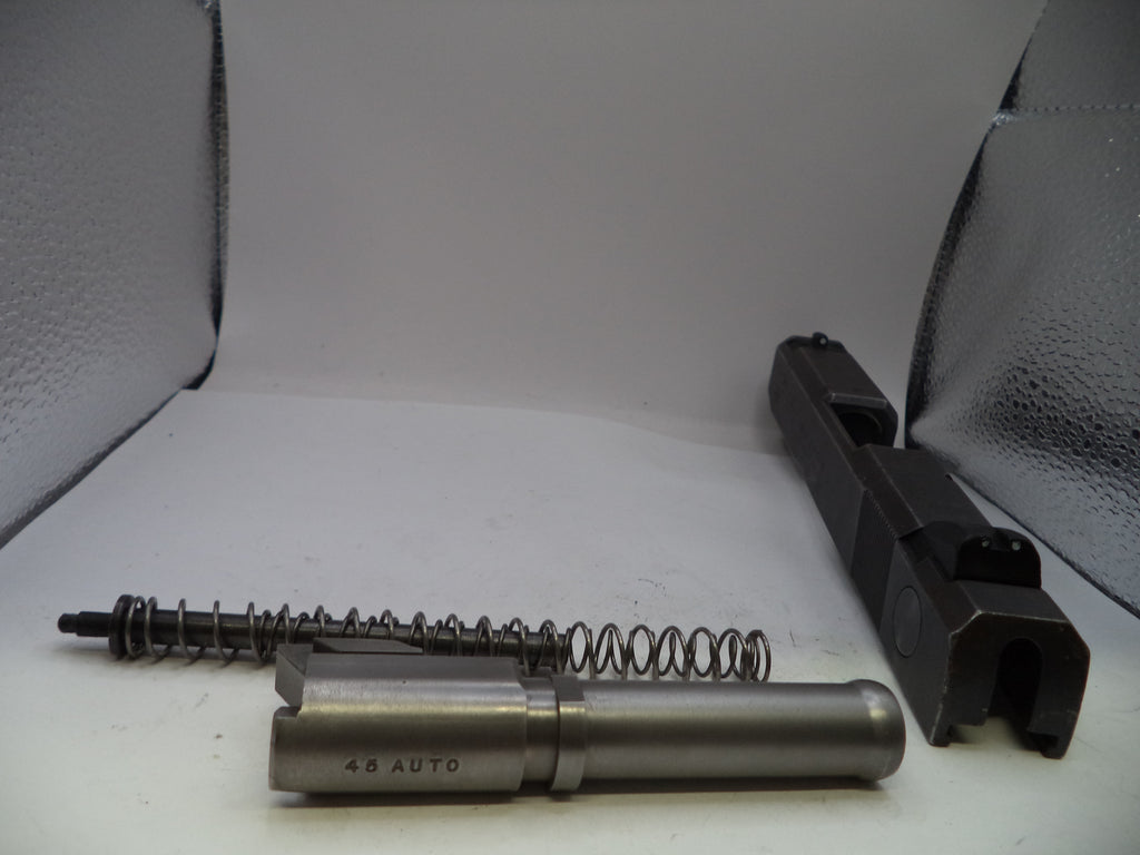 Disassembled firearm components on a white surface with a gray background