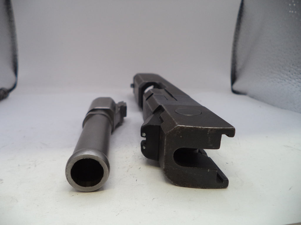Two gun components on a white surface with a gray background