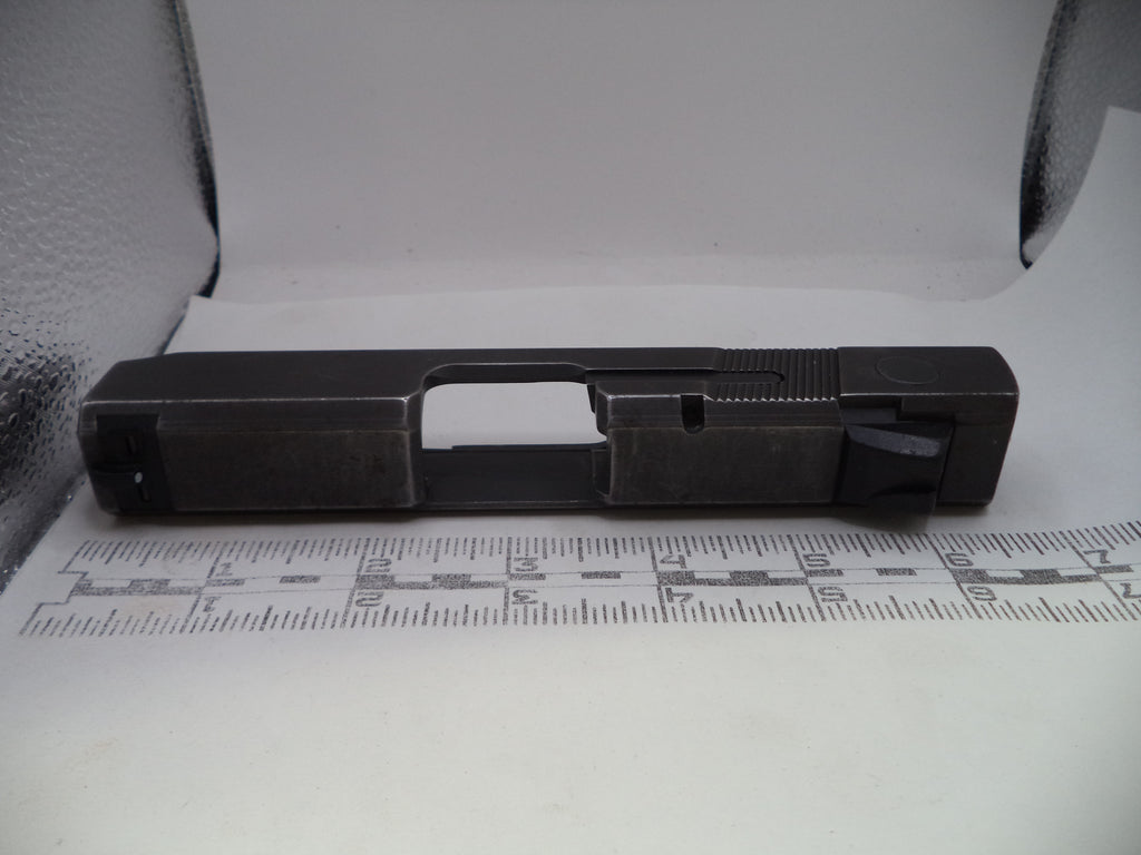 Black metal component on a white surface with measurement scale