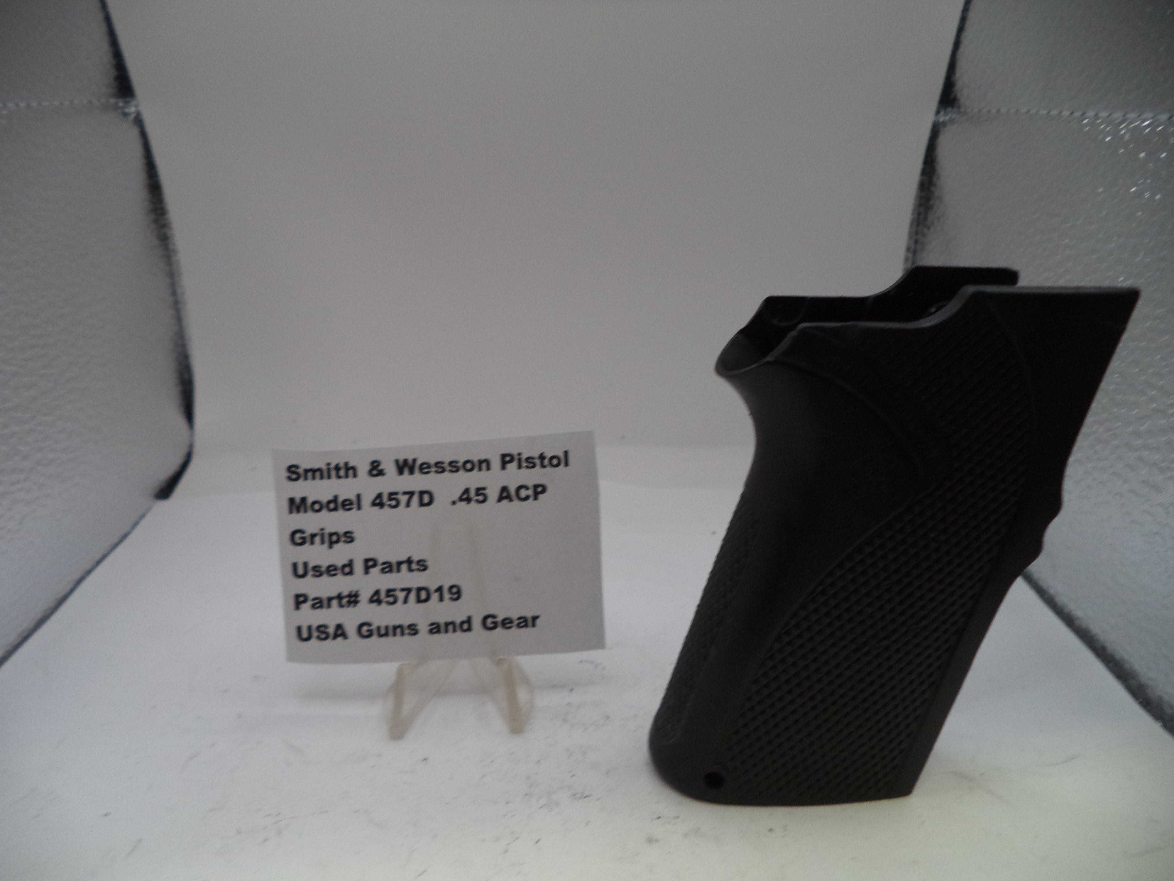 Black gun grip with a label on a white background