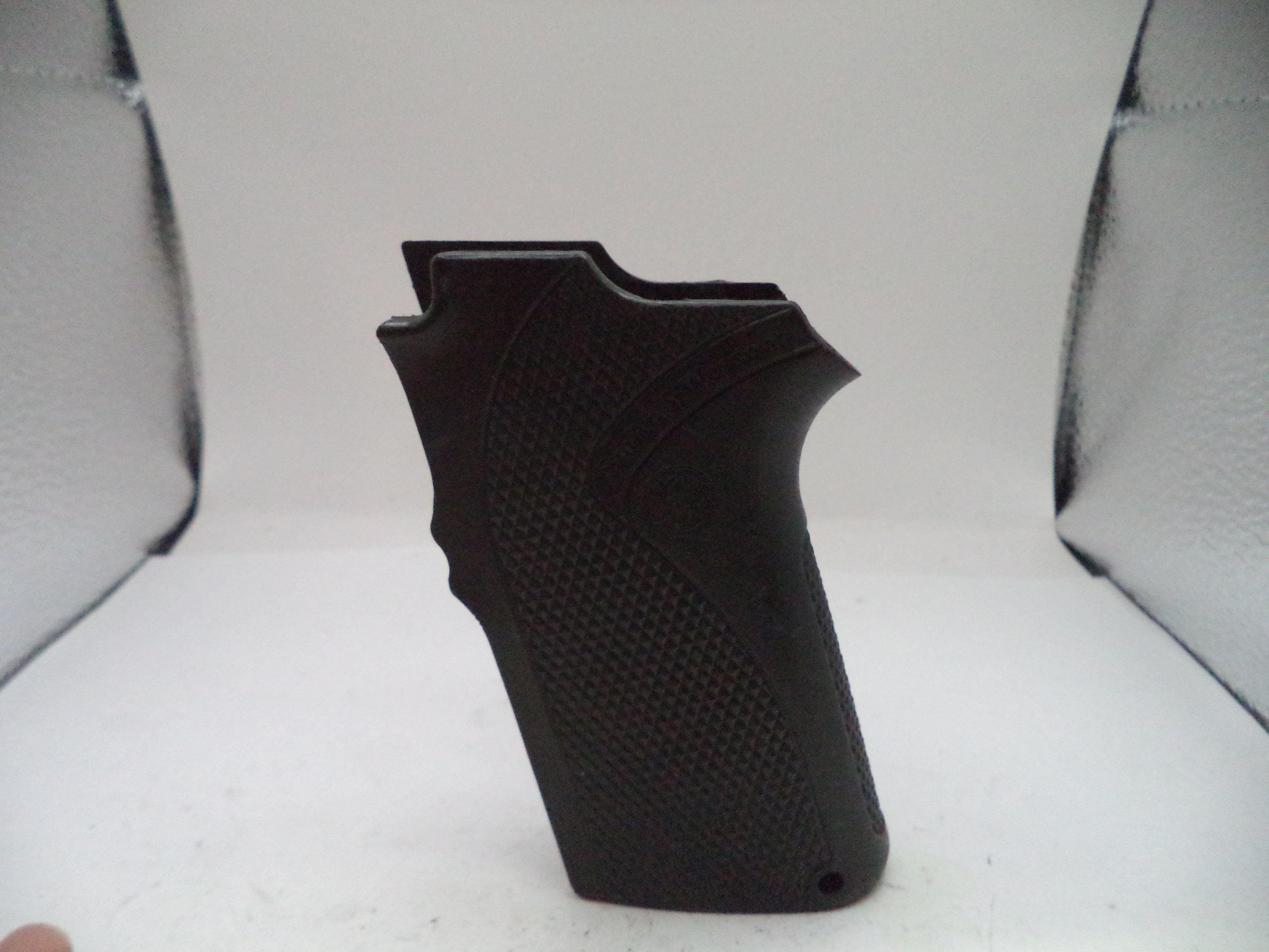 Black textured gun grip on a light gray background