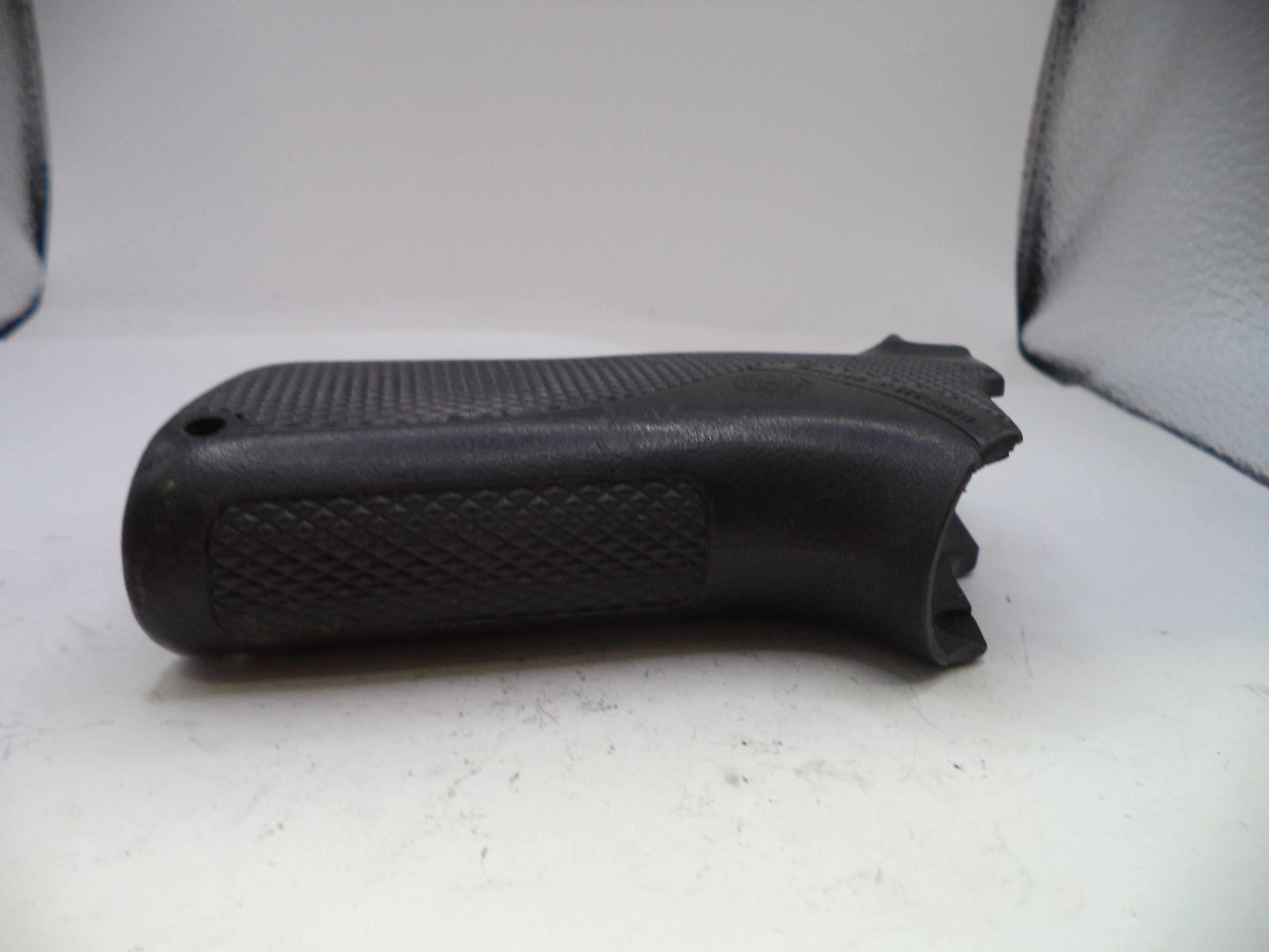 Black gun grip on a white surface