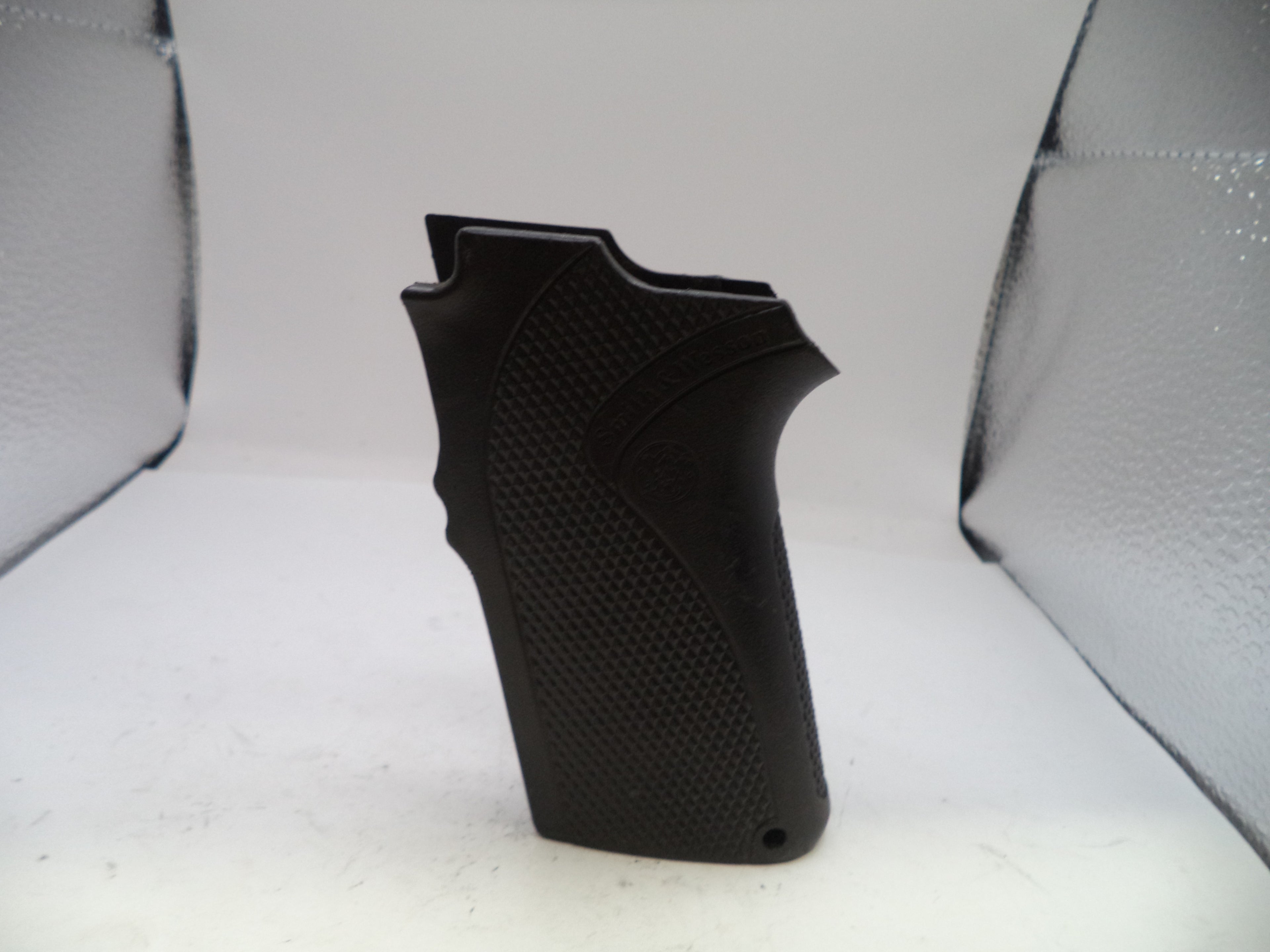 Black textured gun grip on a white background