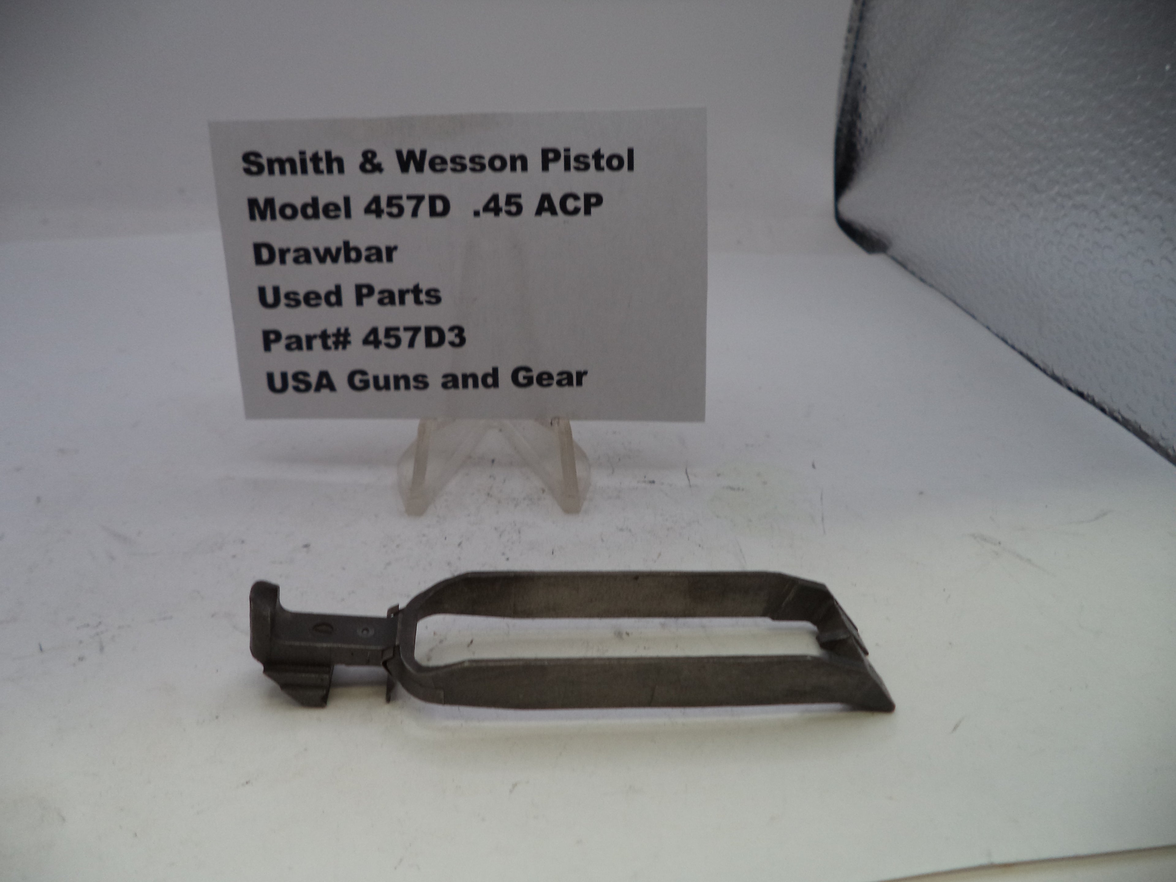 Smith & Wesson pistol drawbar used parts on a white background with a label.