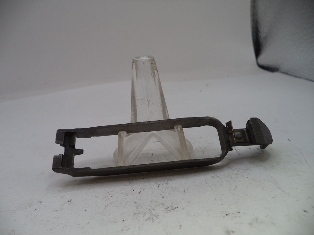 Metal foot pedal on a white surface with a clear stand