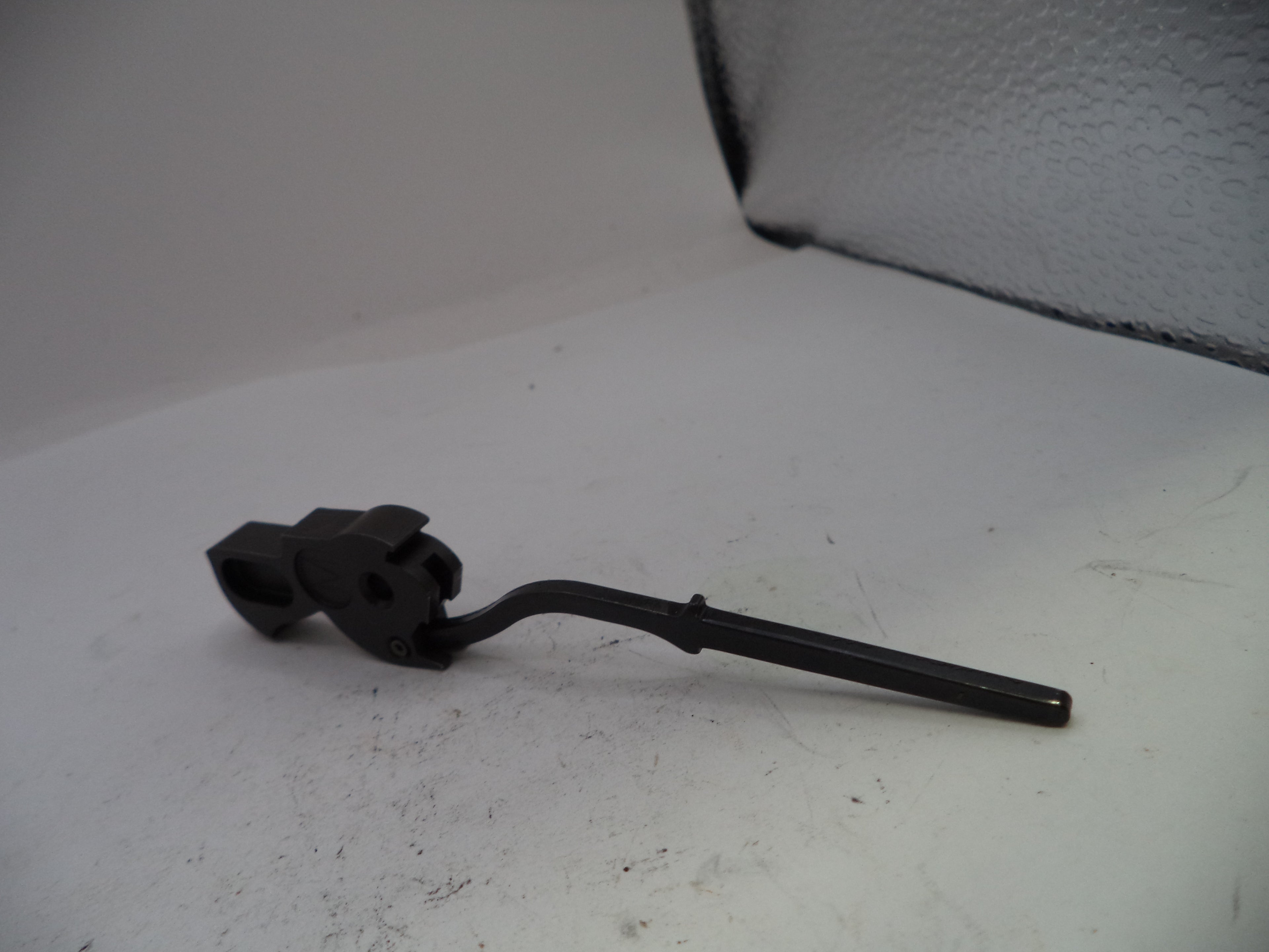 Black metal lever on a white surface with a textured gray background