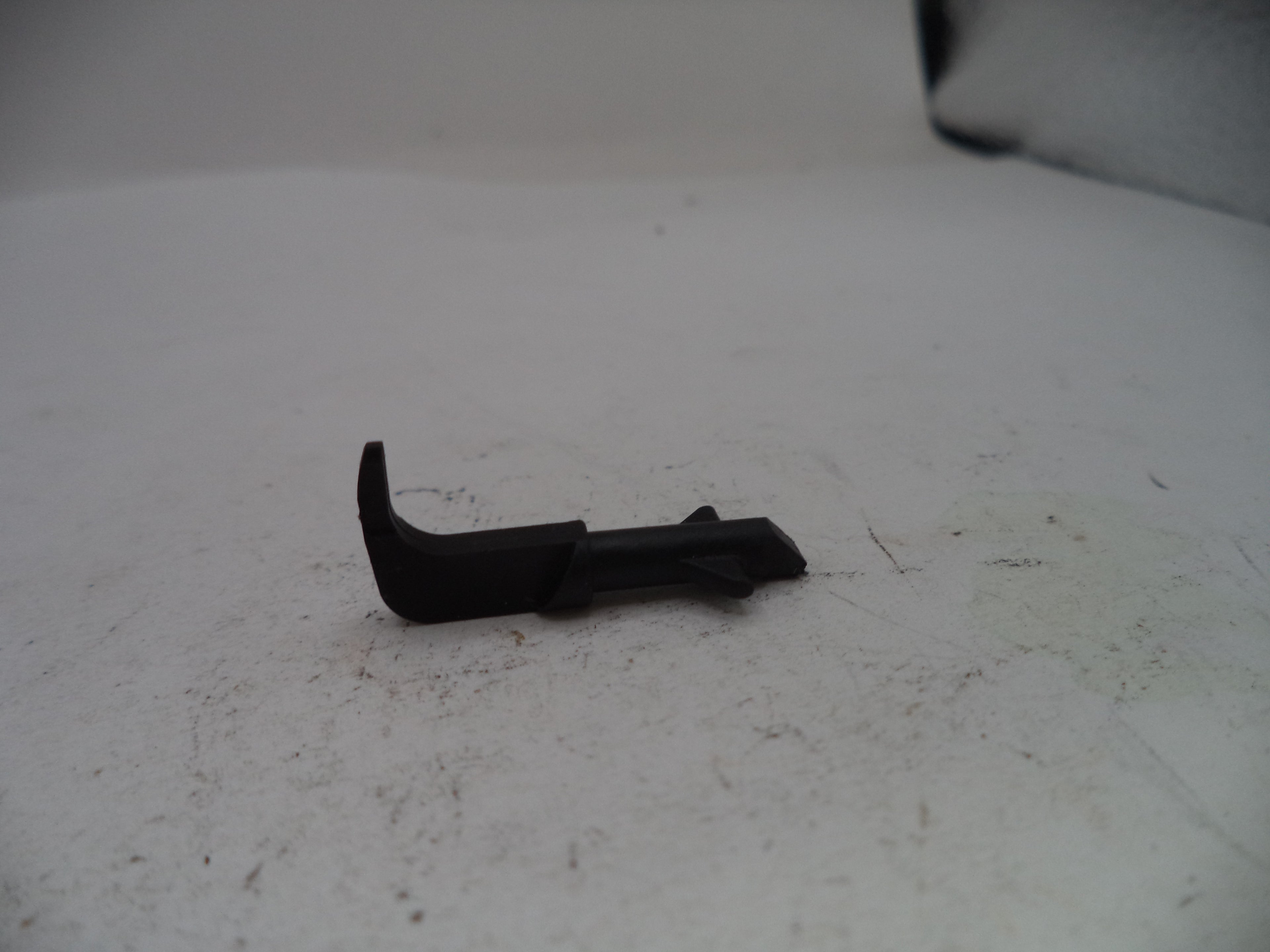 Black plastic component on a white surface