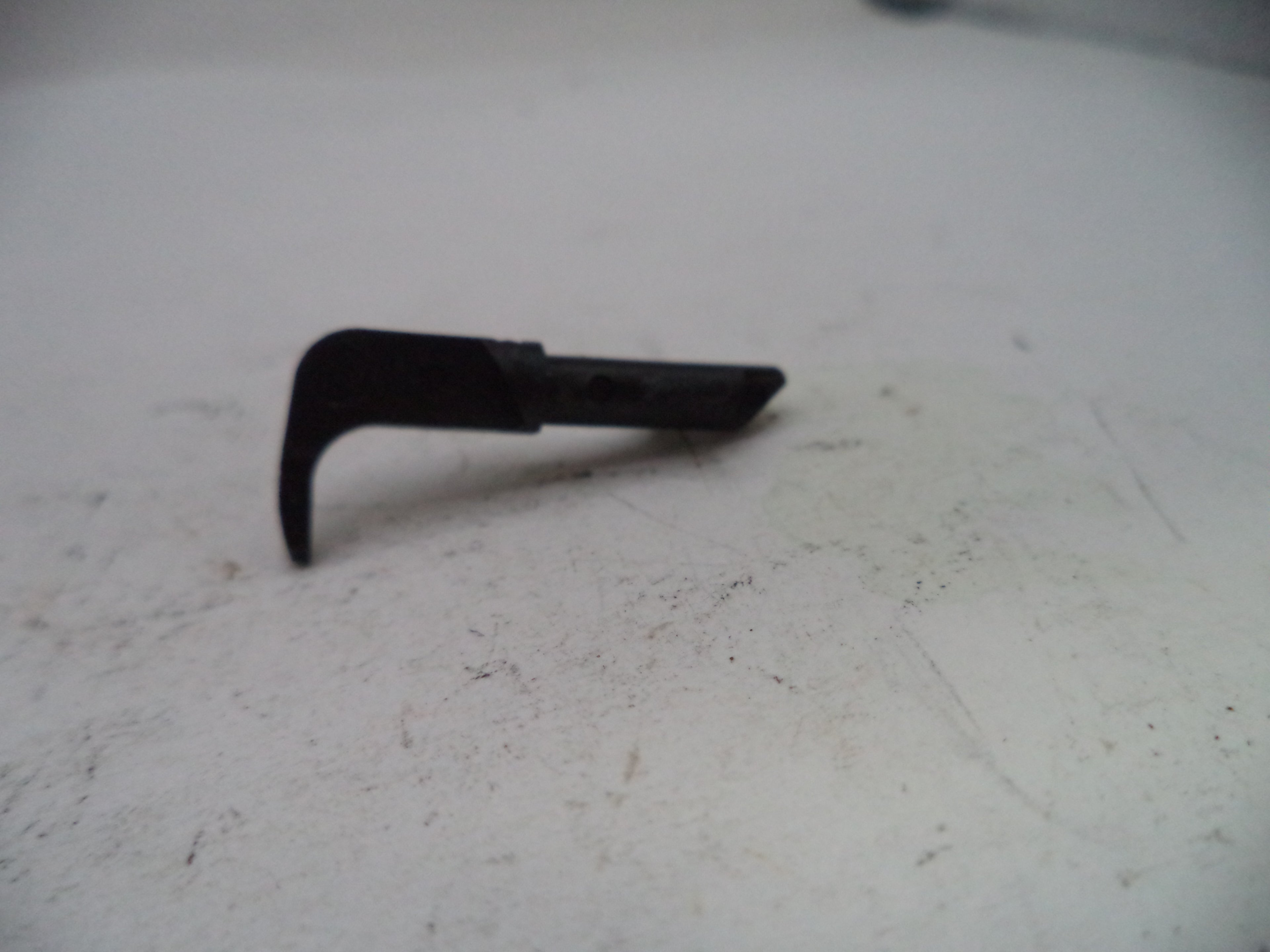 Black metal tool on a white surface