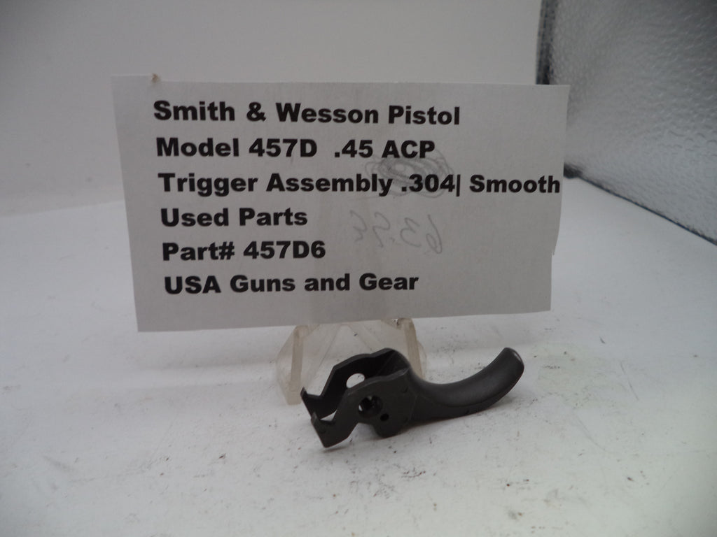 Smith & Wesson pistol trigger assembly on a white background with a label.