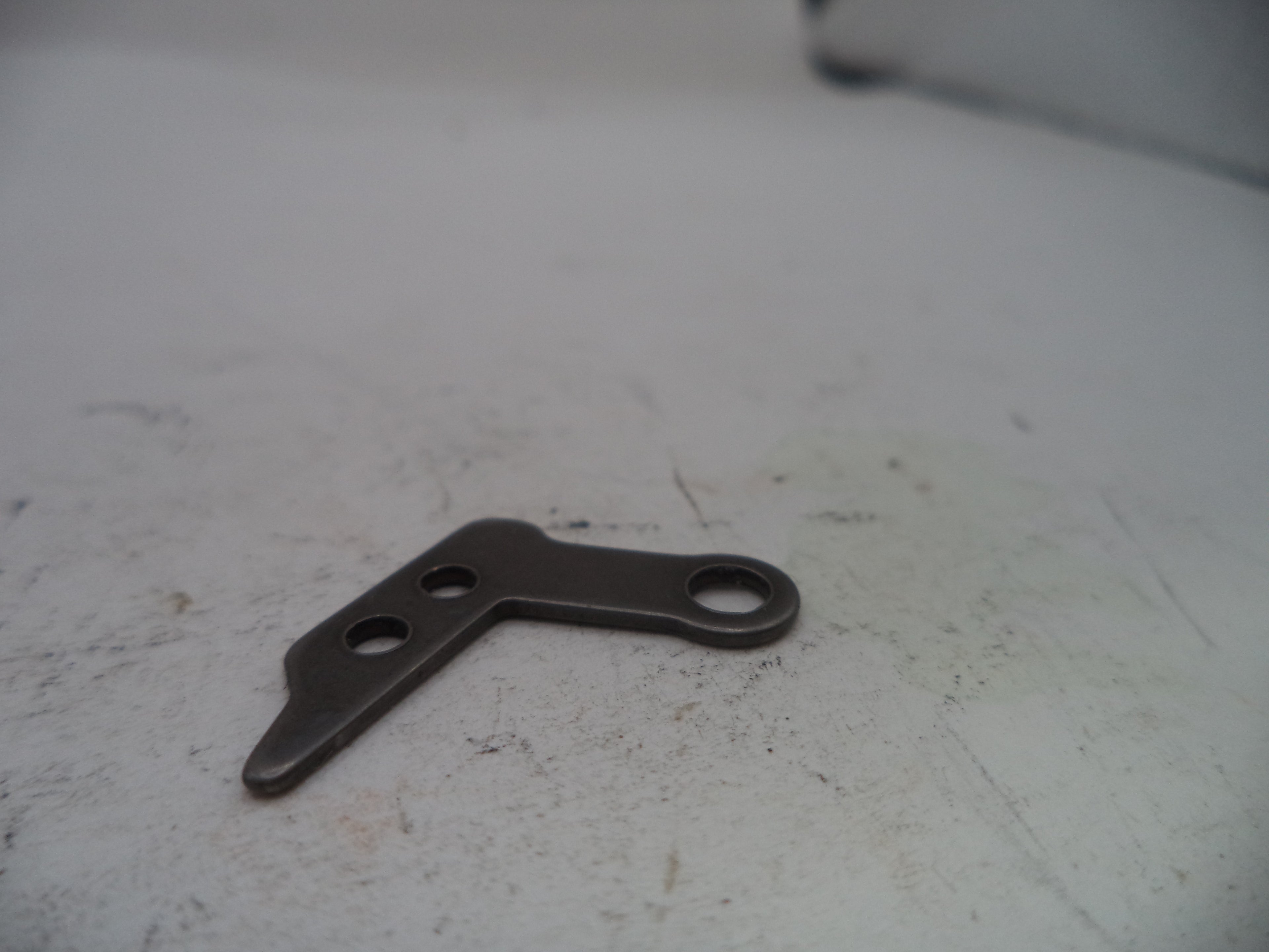 Metal bracket on a worn white surface