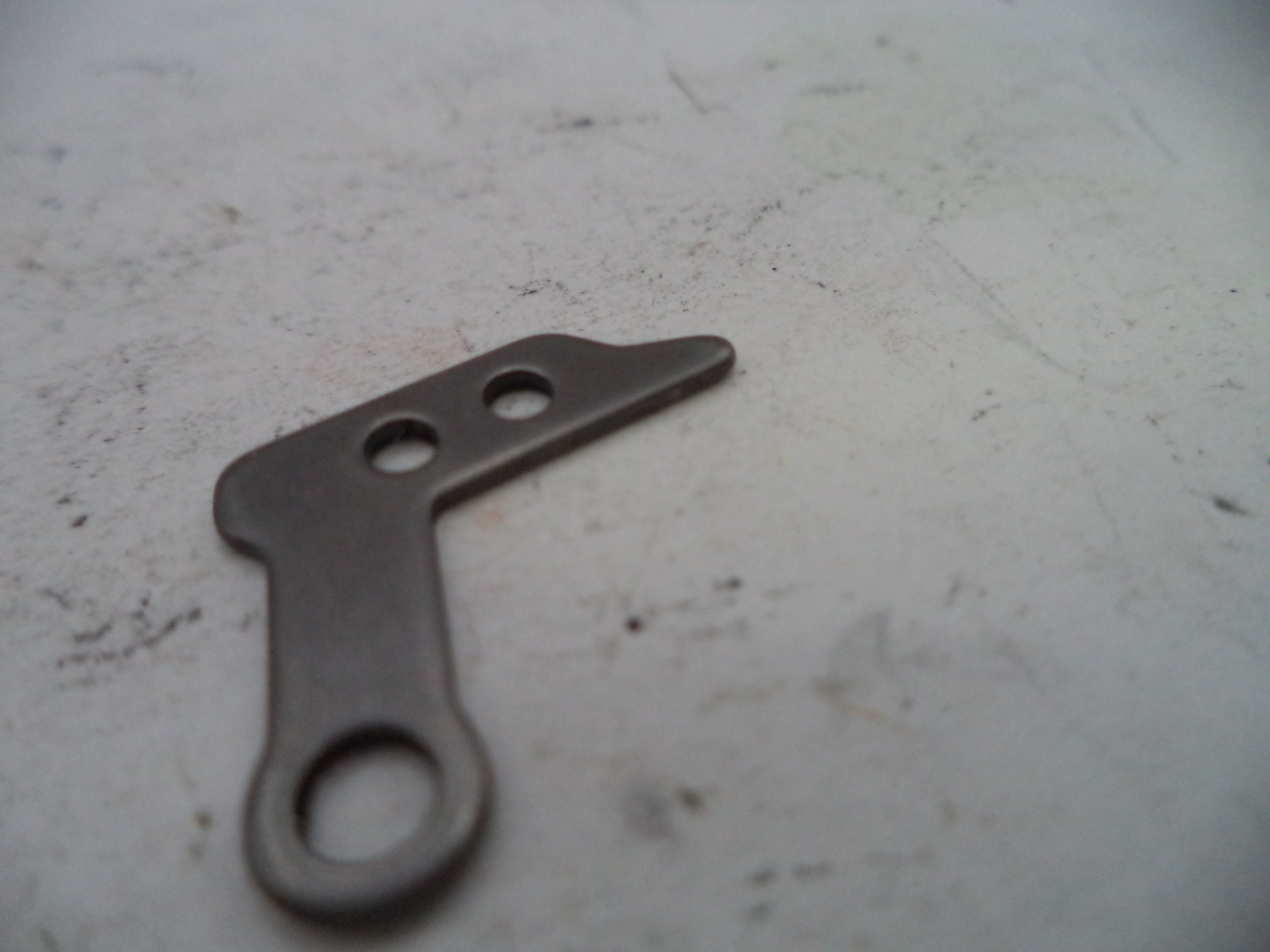 Metallic tool with three holes on a textured surface