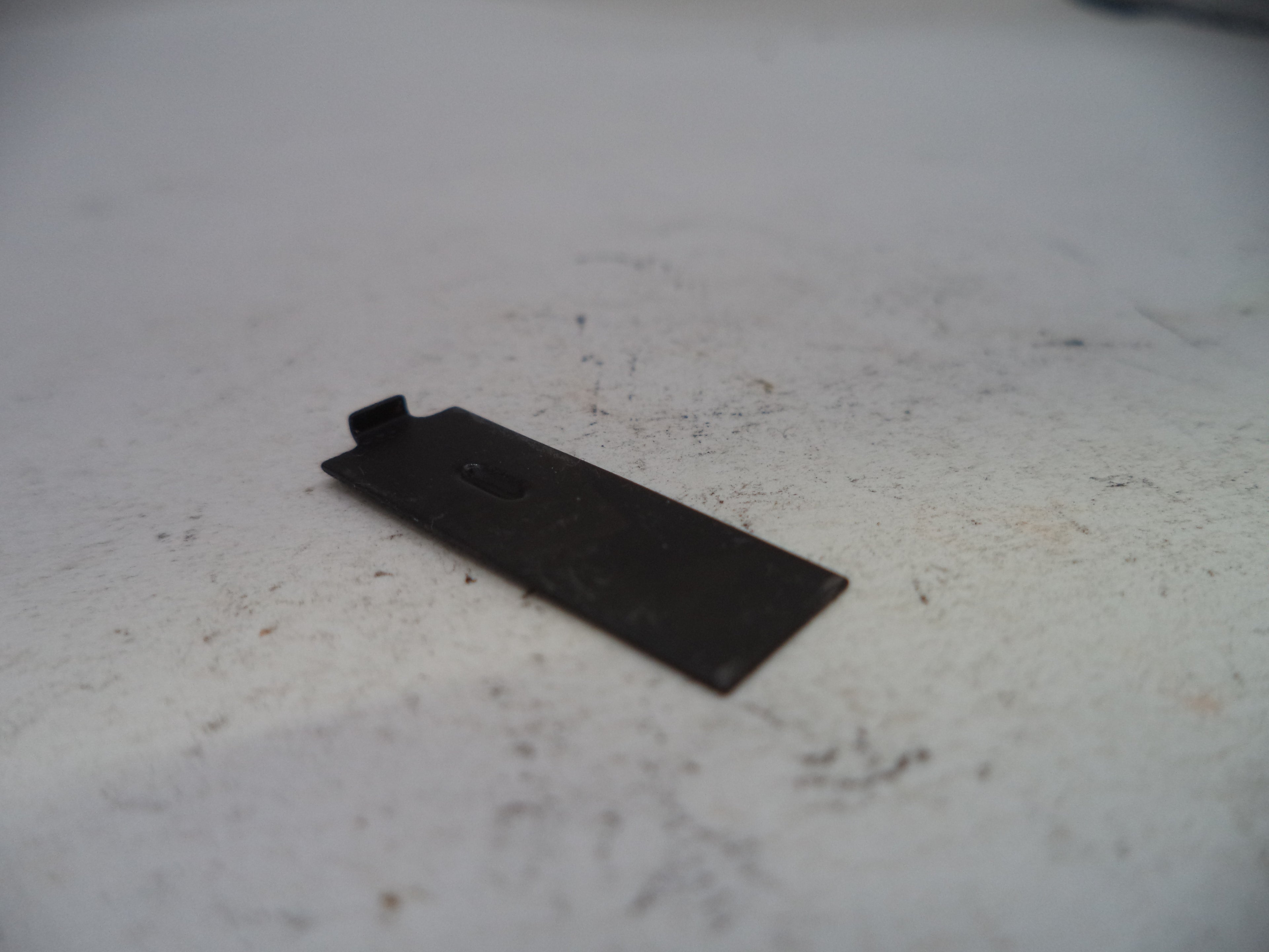 Black metal bracket on a white surface