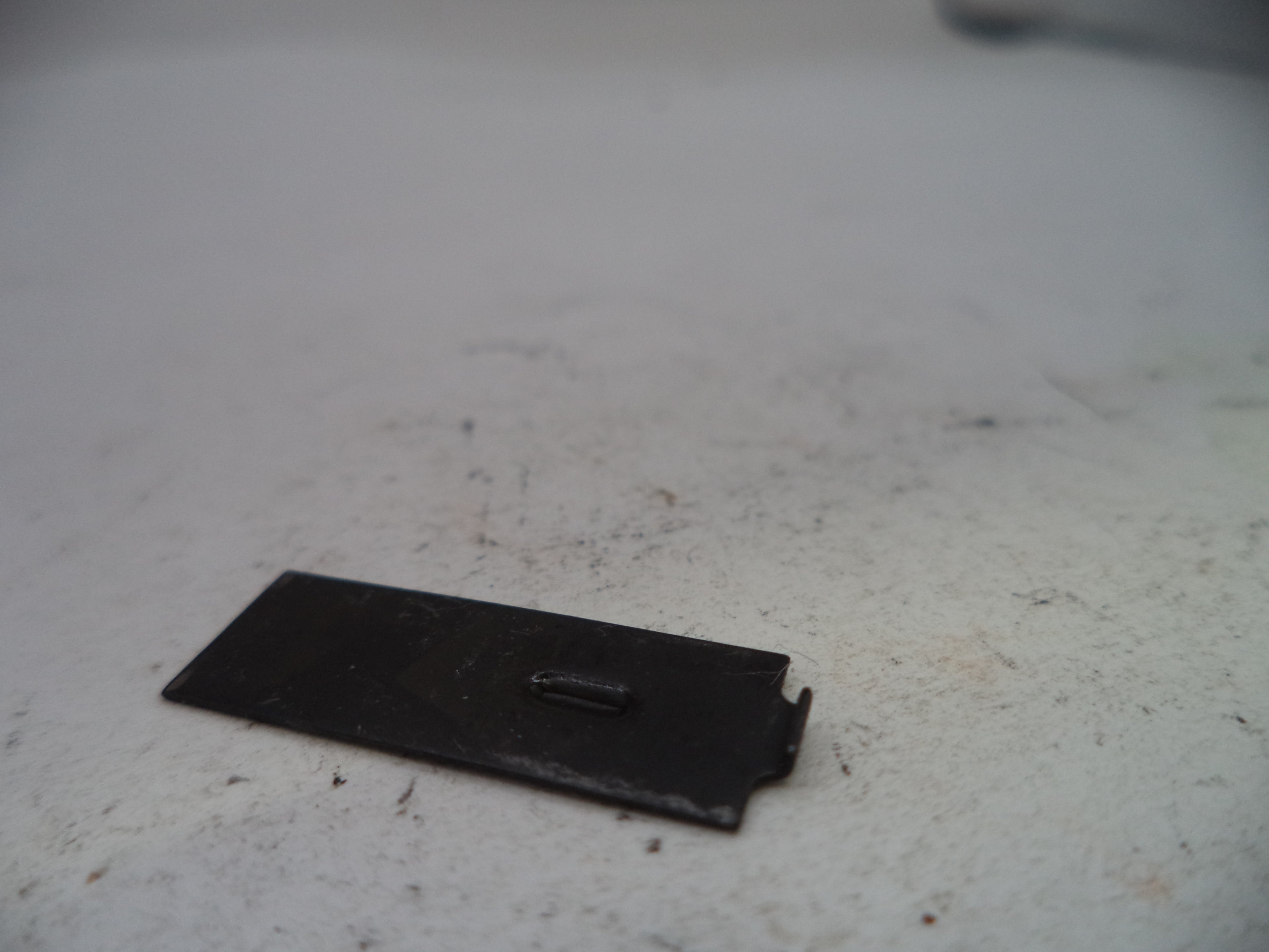 Small black rectangular object on a textured white surface