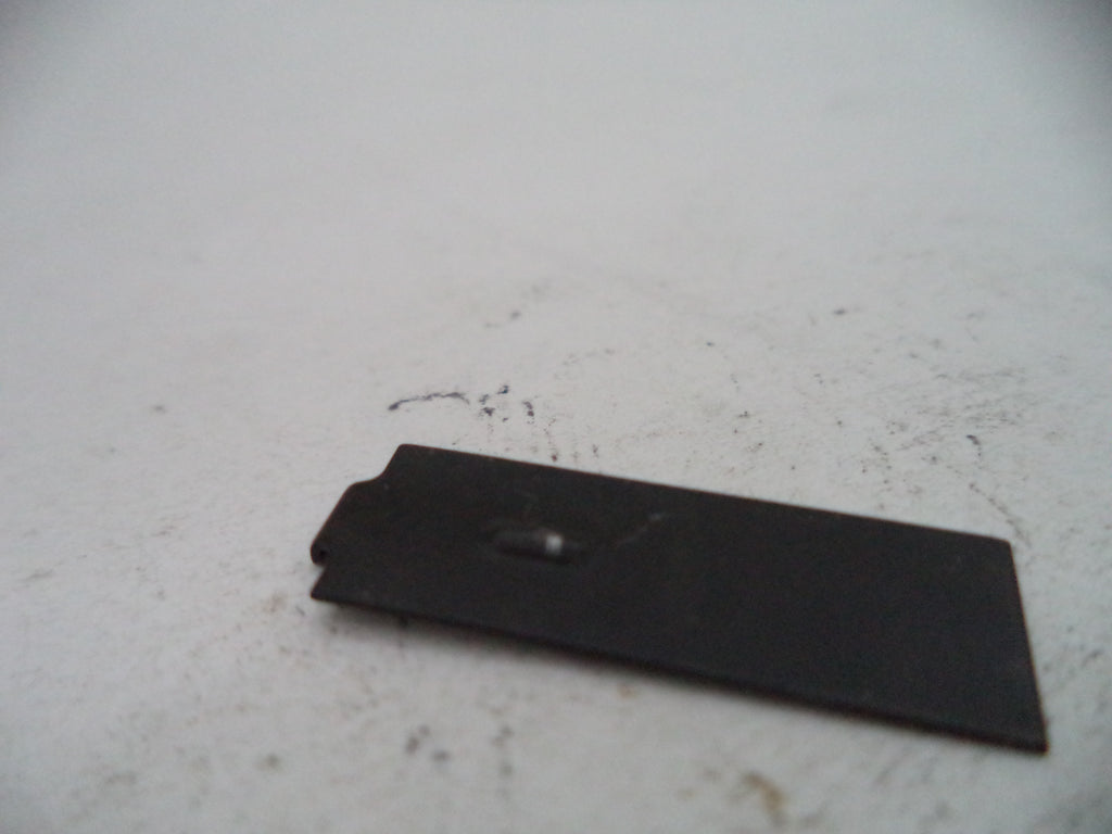 Black rectangular object on a light gray surface