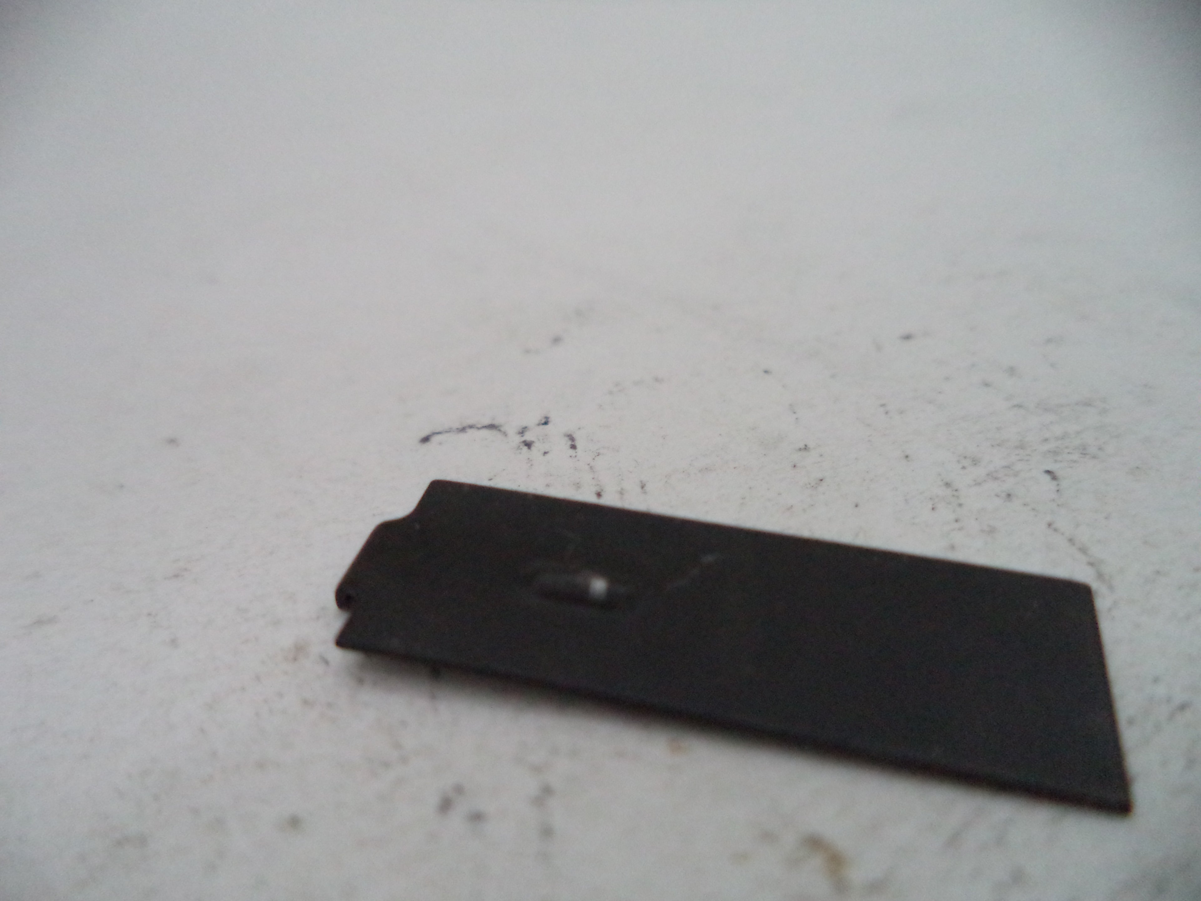 Black rectangular object on a light gray surface