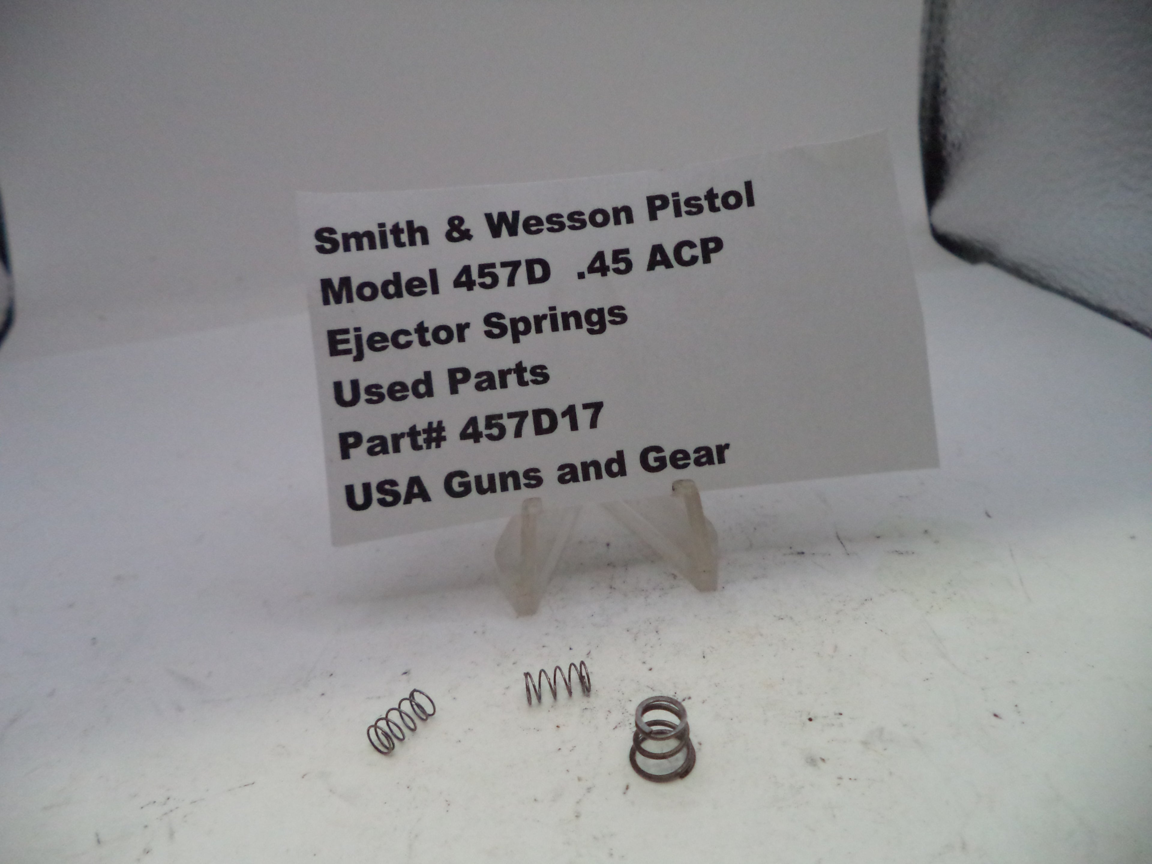 Smith & Wesson pistol ejector springs with a label on a white surface