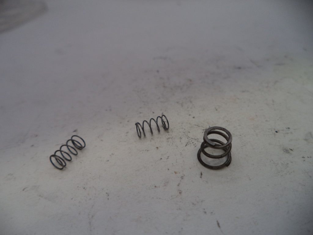 Three metal springs on a white surface