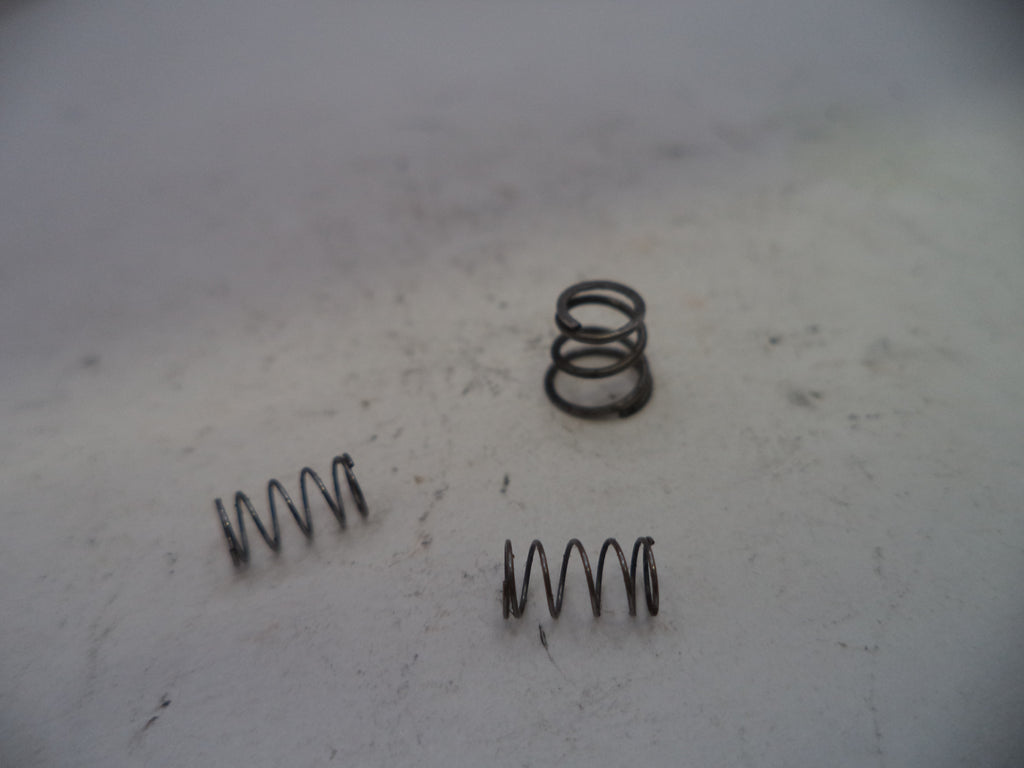 Three metal springs on a textured white surface