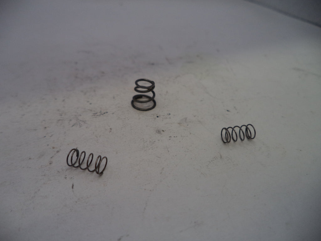 Three metal springs on a worn white surface