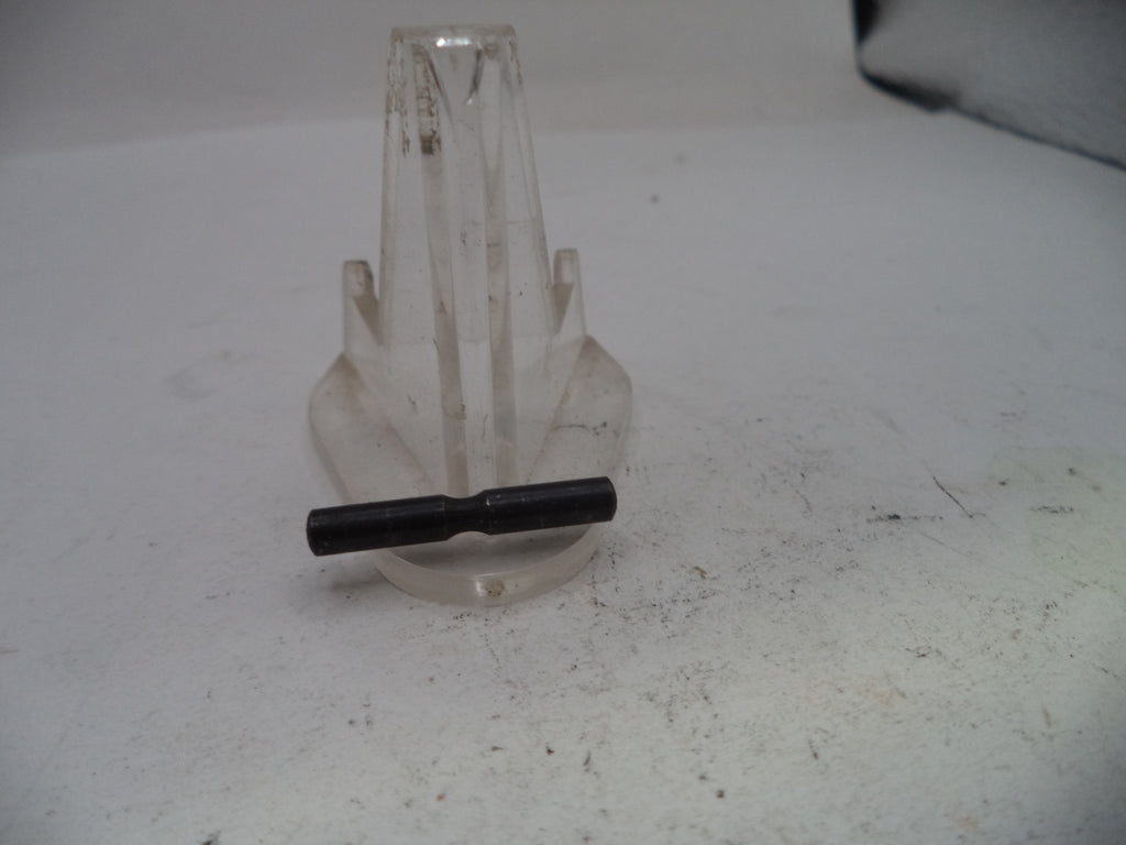 Clear plastic stand with a black object on a white surface