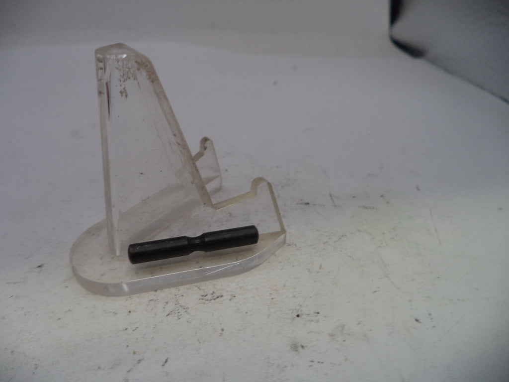 Clear plastic stand with a black cylindrical object on a white surface