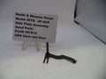 Black Smith & Wesson pistol side plate assembly on a white background with a label.