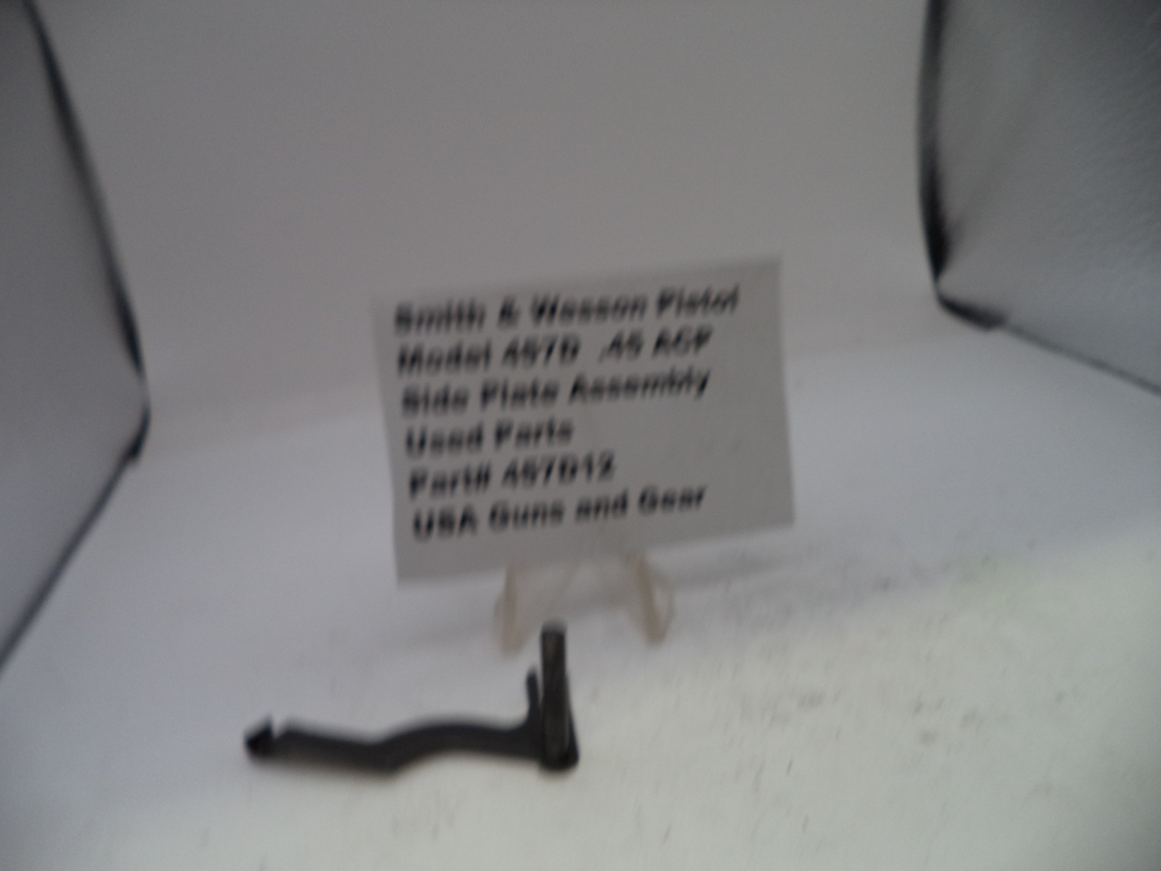 Smith & Wesson pistol part on a white surface with a label.