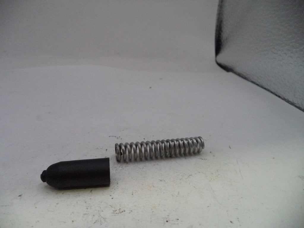 Black rubber tip and metal spring on a white surface