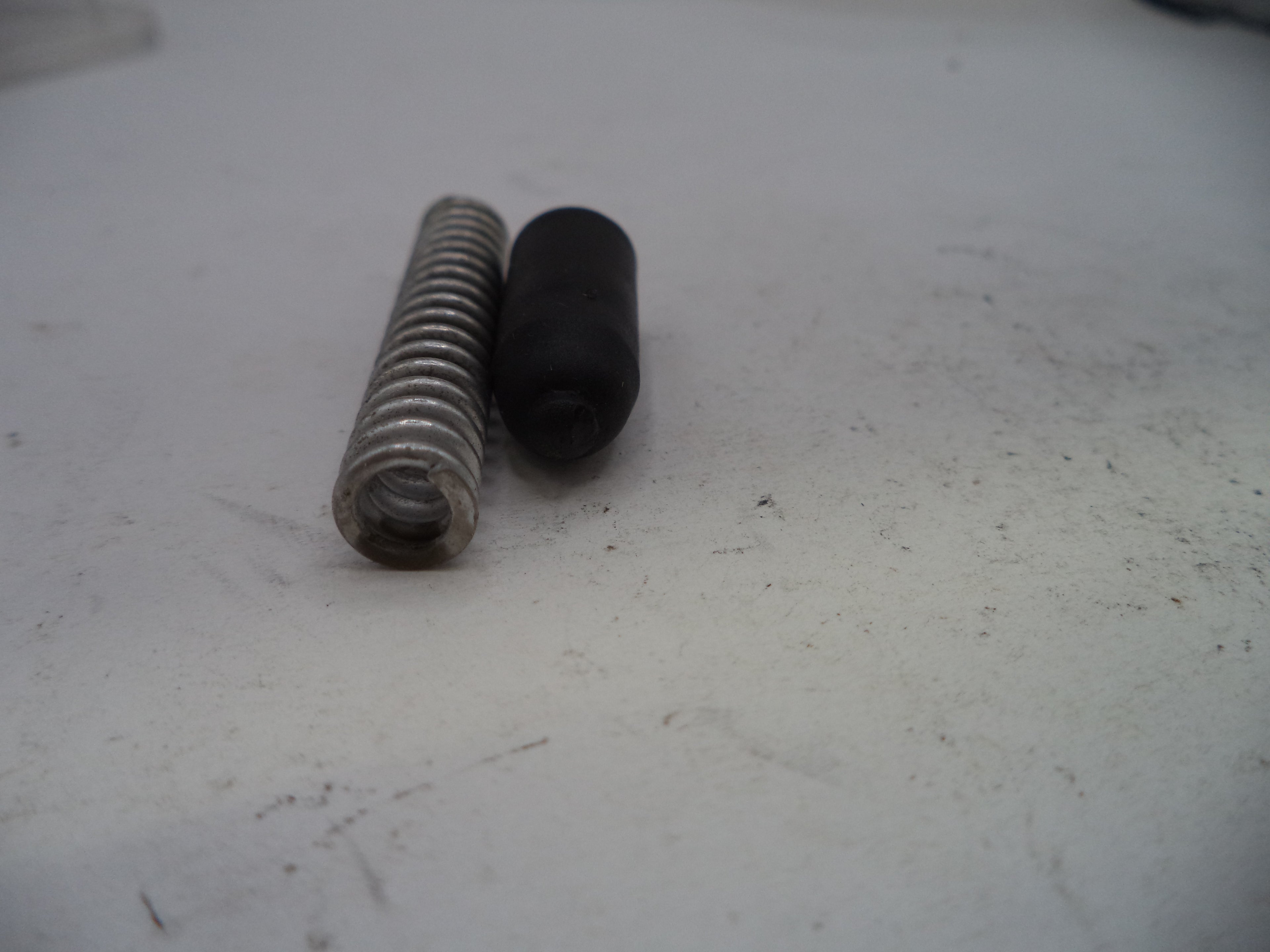 Two metal screws on a textured white surface