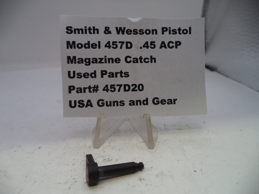 Smith & Wesson pistol magazine catch on a white surface with a label.