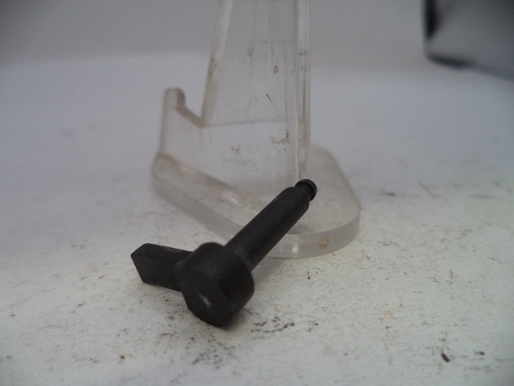 Black screw on a white surface with a clear plastic stand in the background