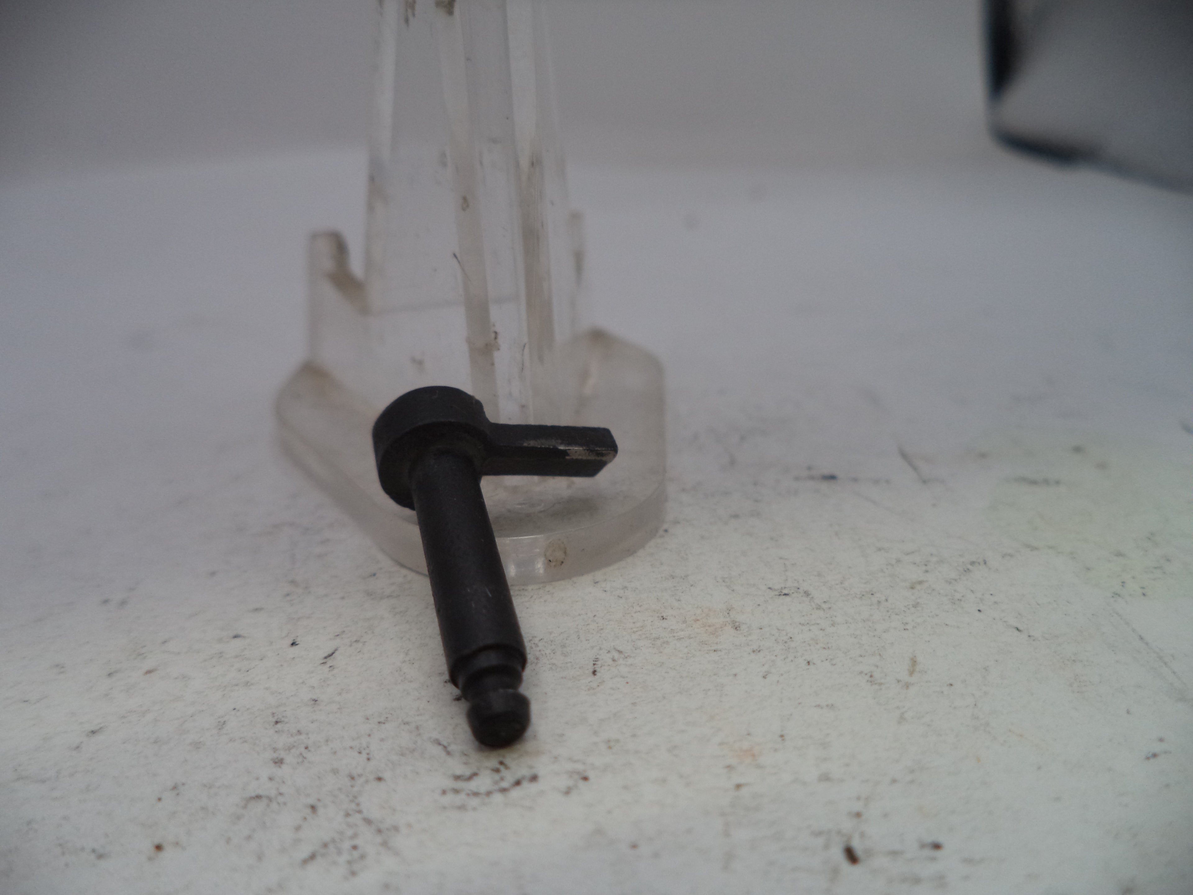 Small black metal component on a white surface
