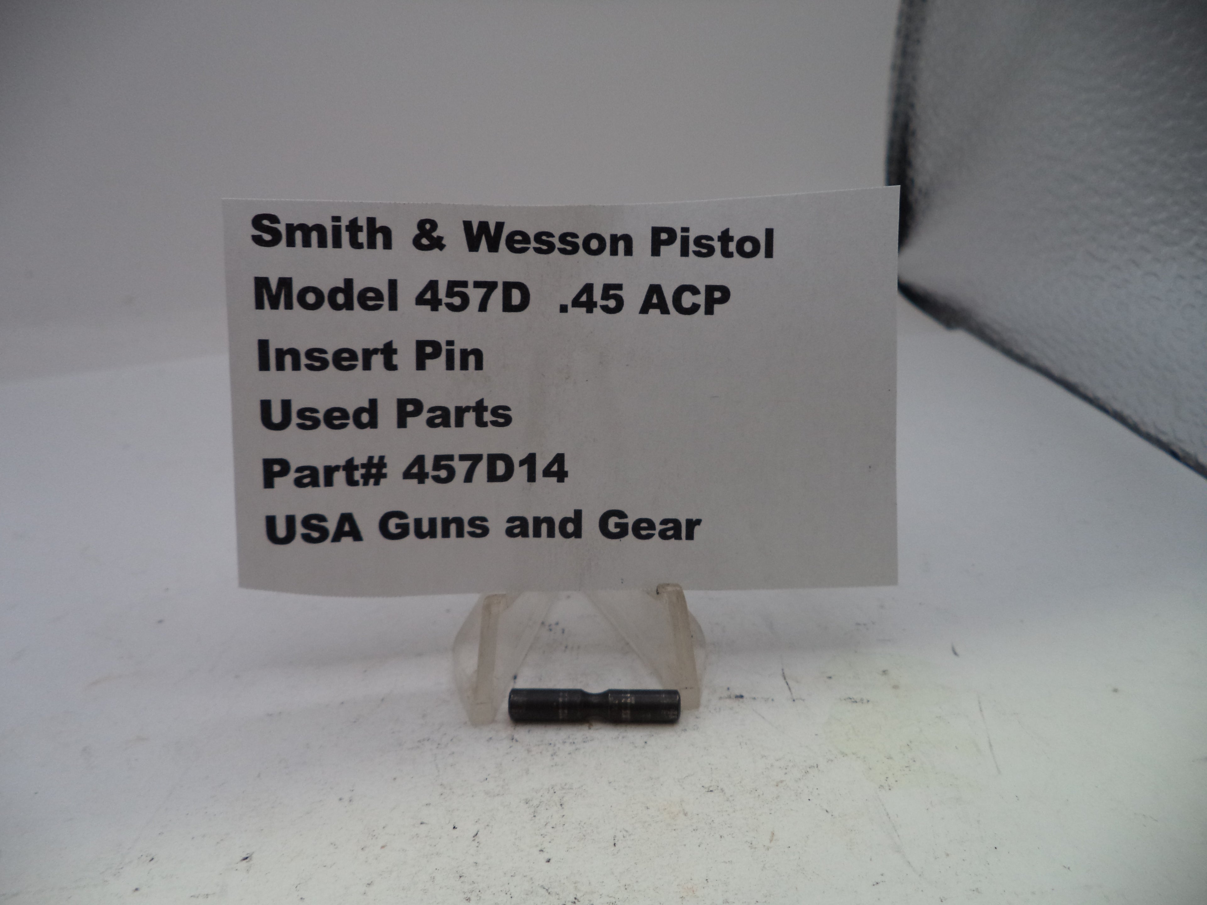 Smith & Wesson pistol part with label on a white background