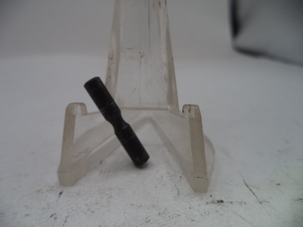 Black cylindrical object on a clear plastic stand against a white background