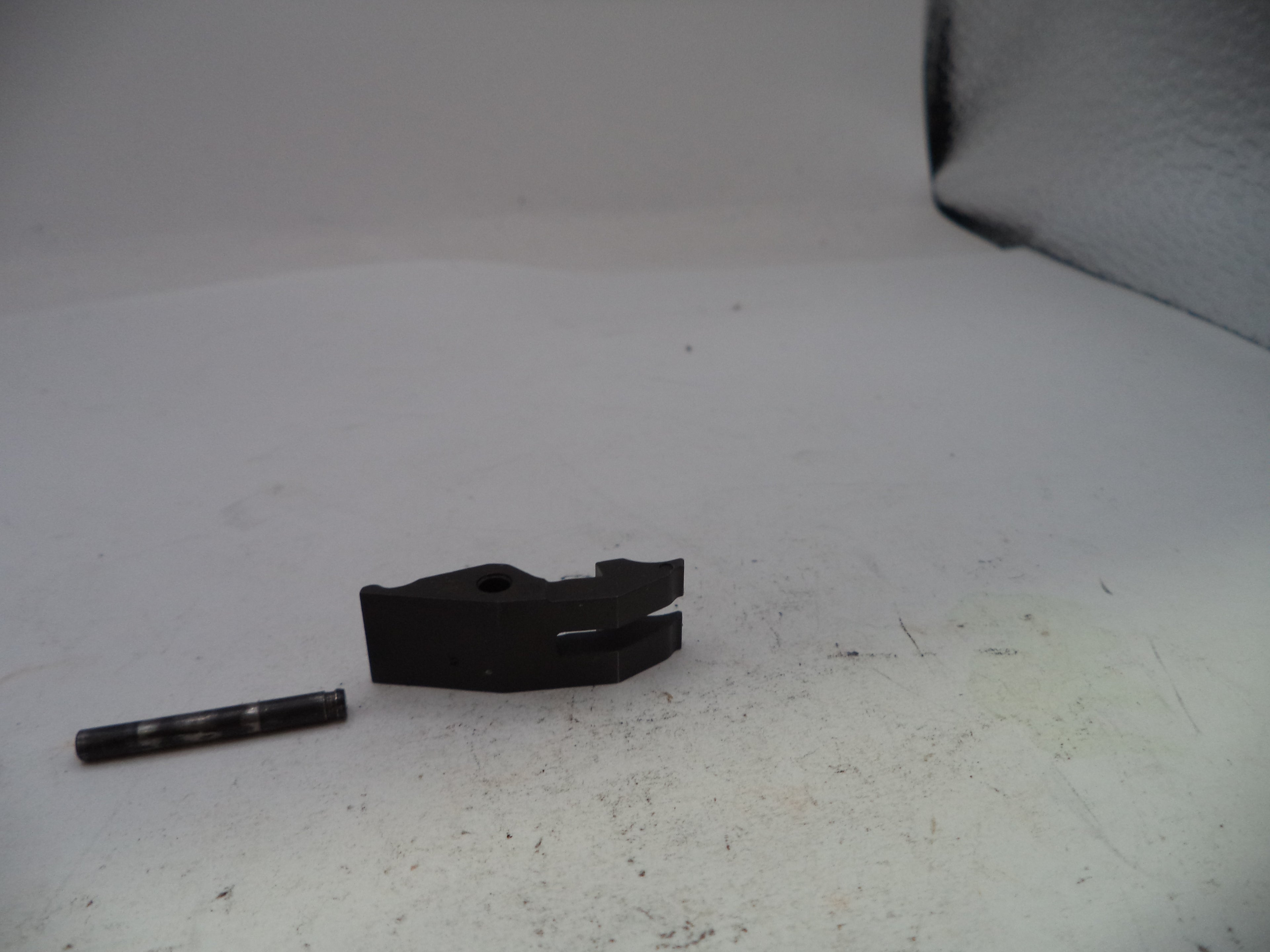Two black mechanical parts on a white surface