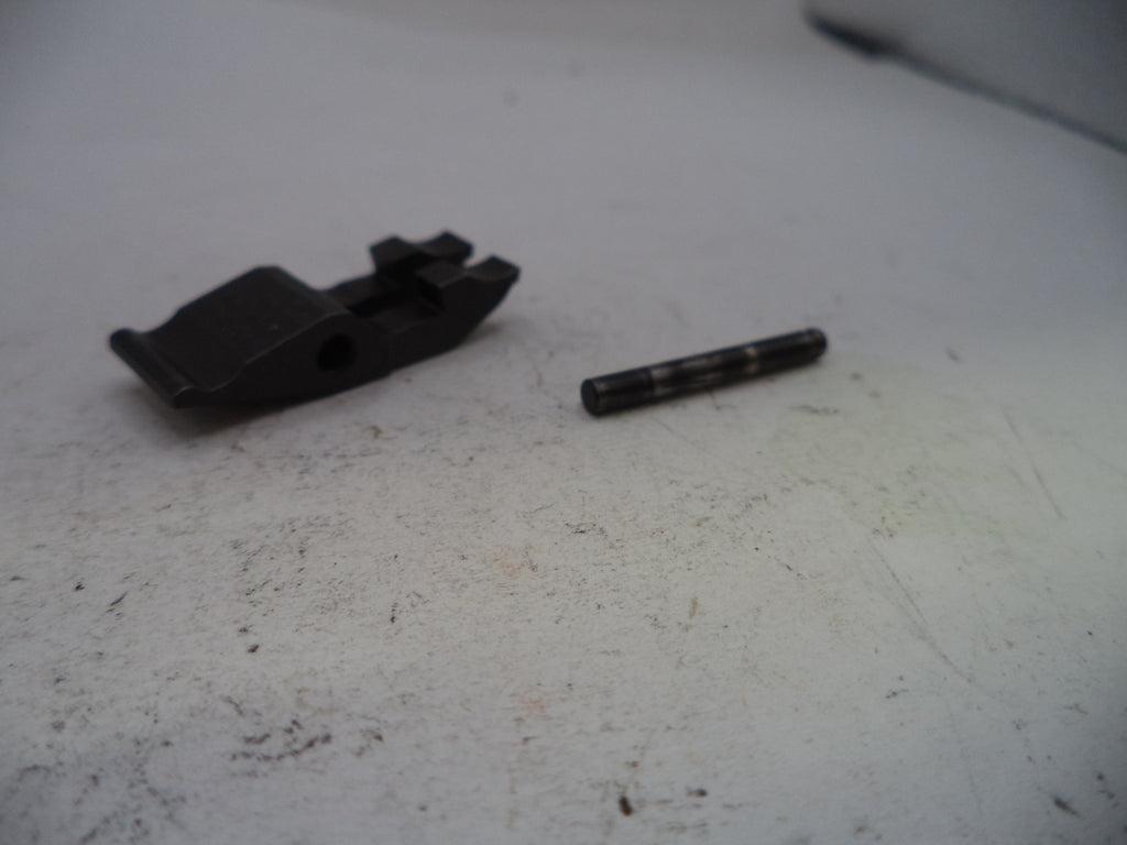 Two black mechanical parts on a worn white surface
